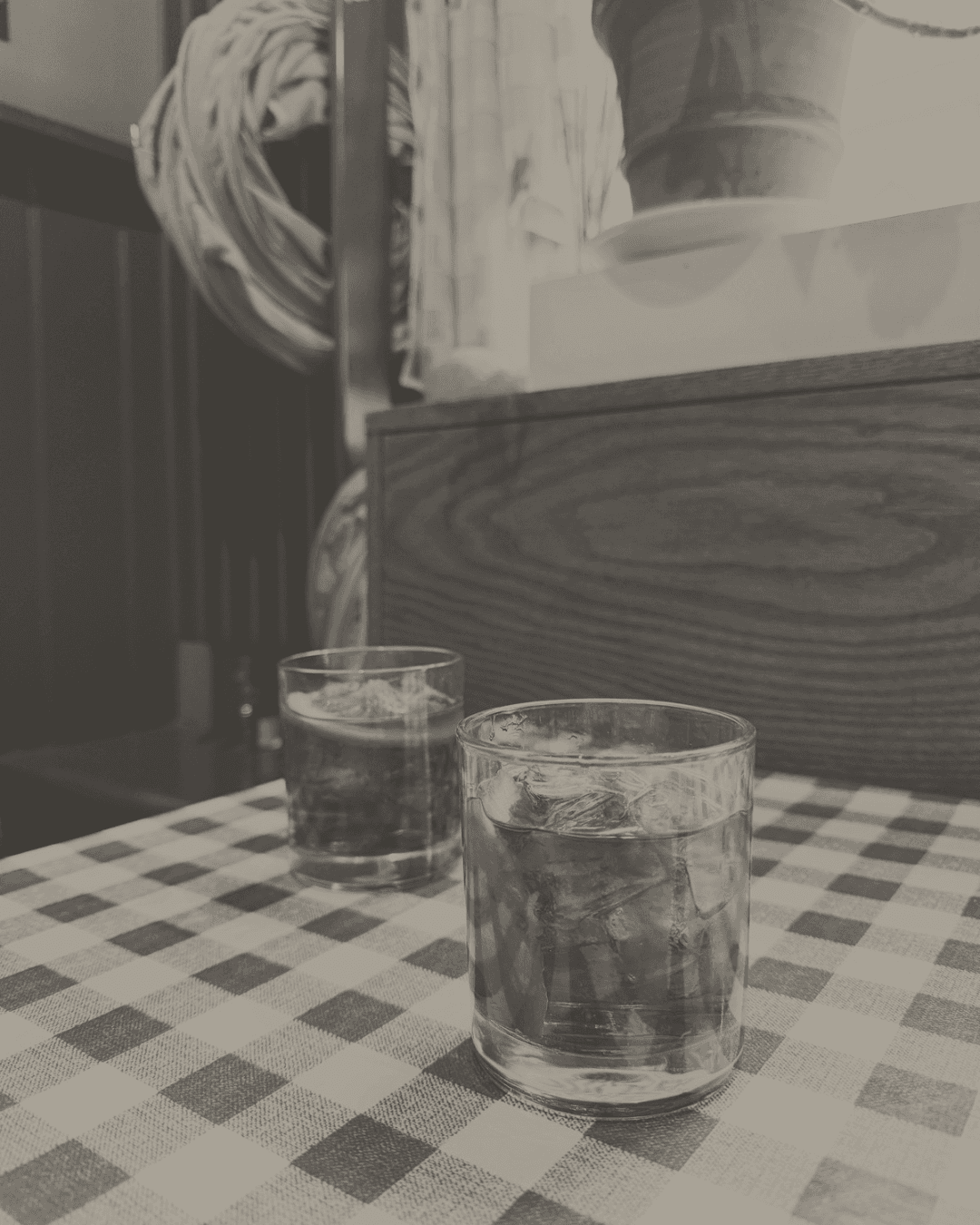 Two Negronis on a checked tablecloth in a wood-panelled pub interior