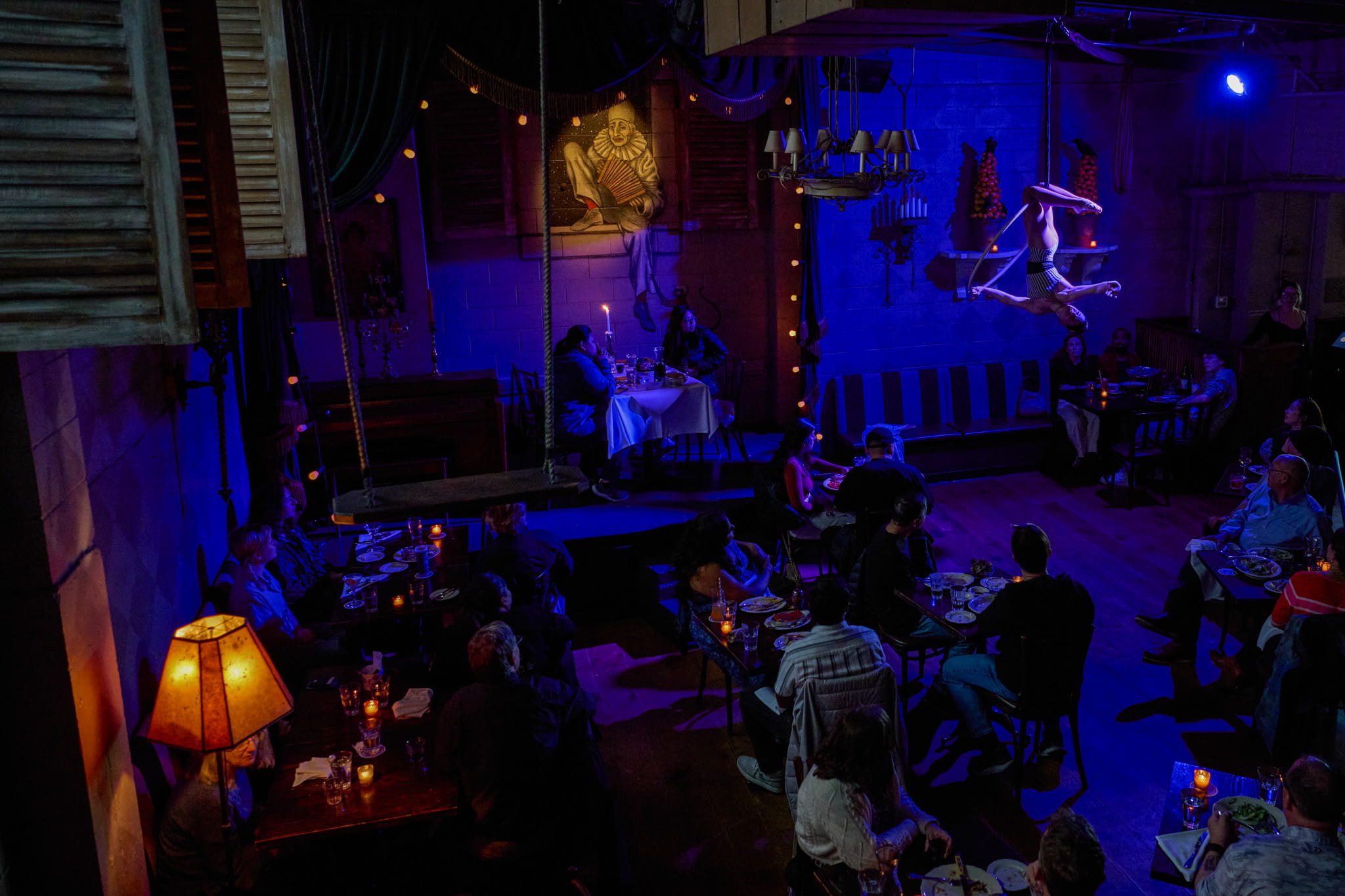The Pink Door Lounge in dim blue light with aerial performer