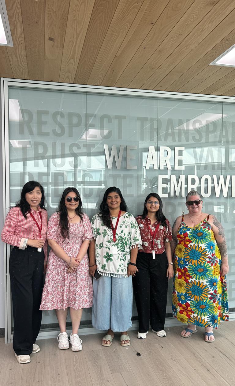 5 Women Standing in the front of an 'Empowered' backdrop