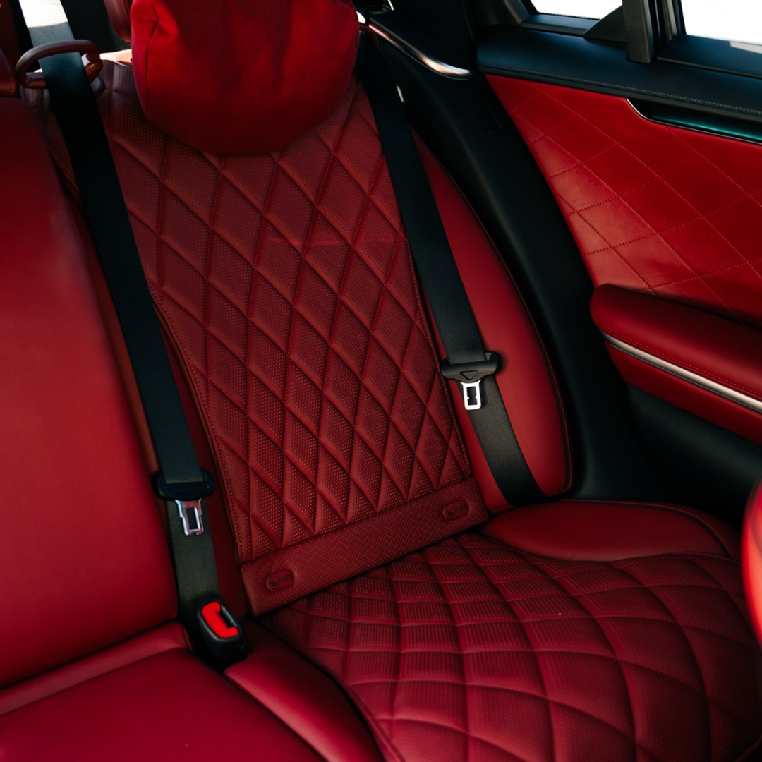 Luxurious rear passenger seats of the black Mercedes-Benz S 580, showcasing quilted red leather upholstery.