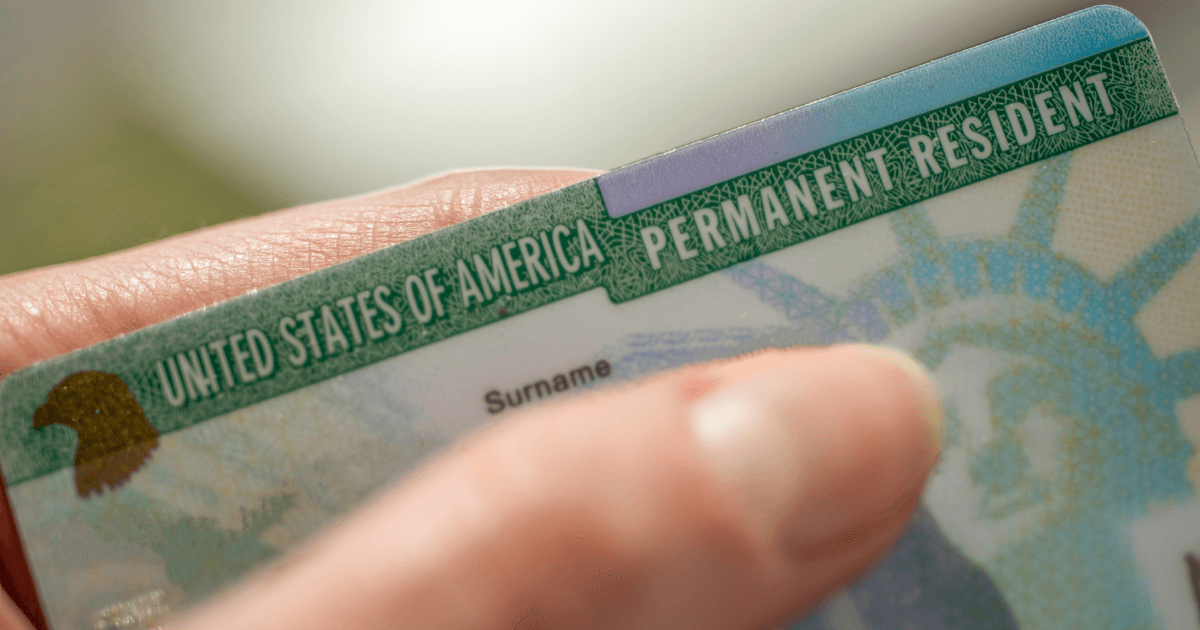 An image of a green card, possibly with a U.S. flag or map in the background.