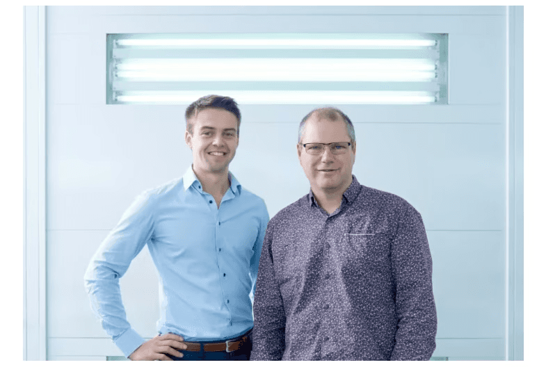 Co founders of Ellio bikes standing against a wall