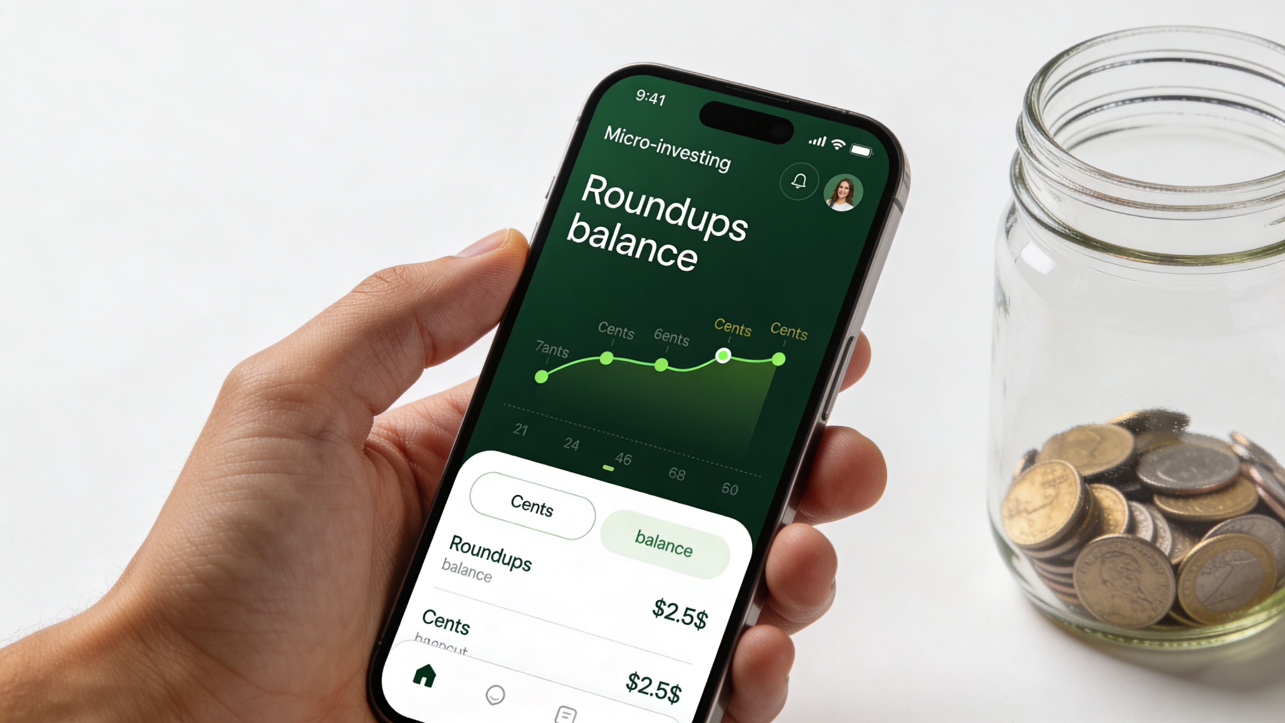 A hand holding a smartphone showing a micro-investing mobile application screen next to a glass coin jar.
