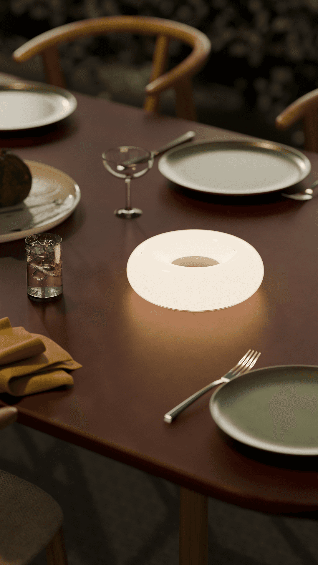 A donut shaped lamp on an outside table.