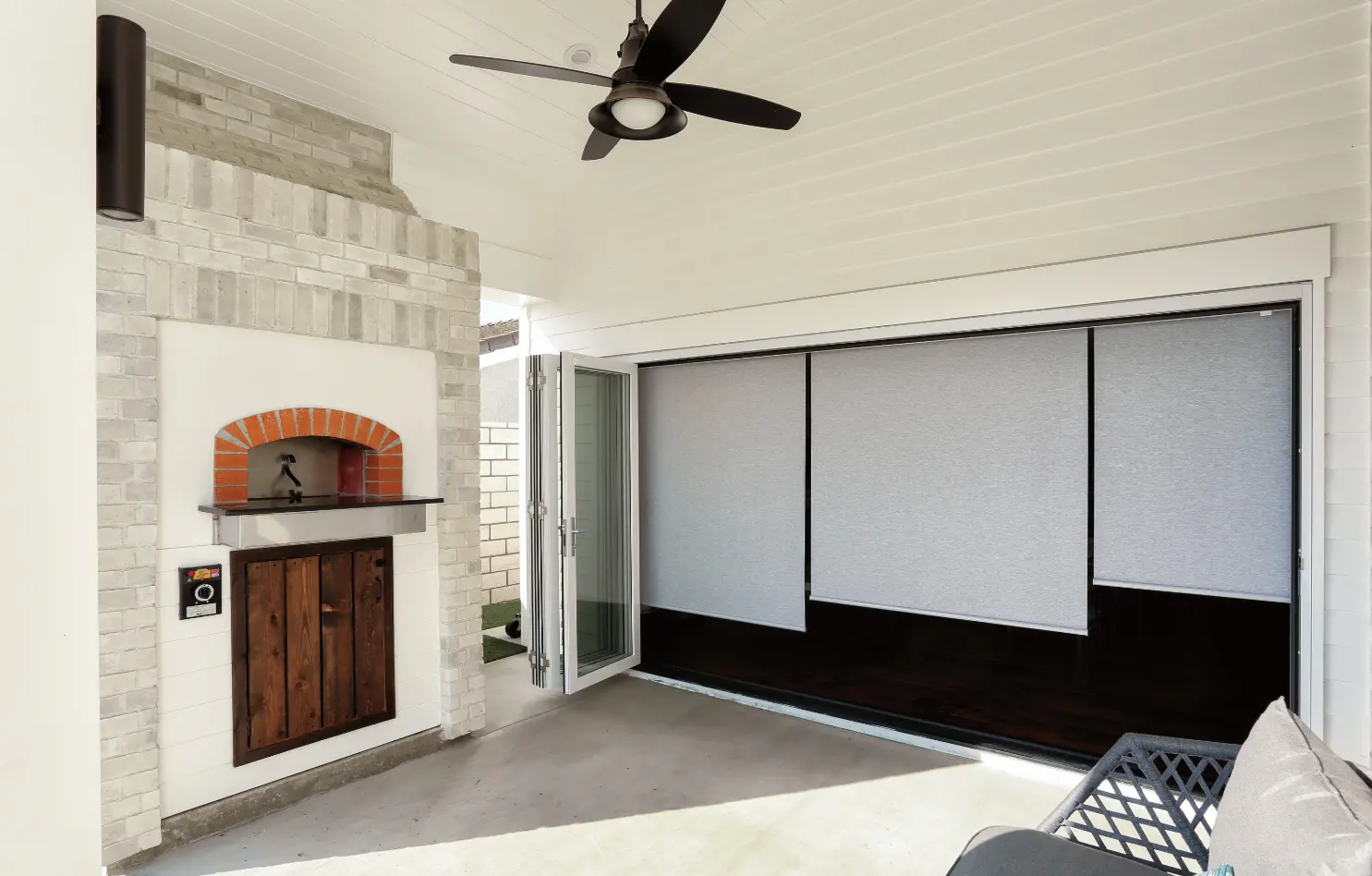 Front yard covered patio with brick fire pizza stove and large bi-fold door with motorized shades. Photo by Chris Darnall.