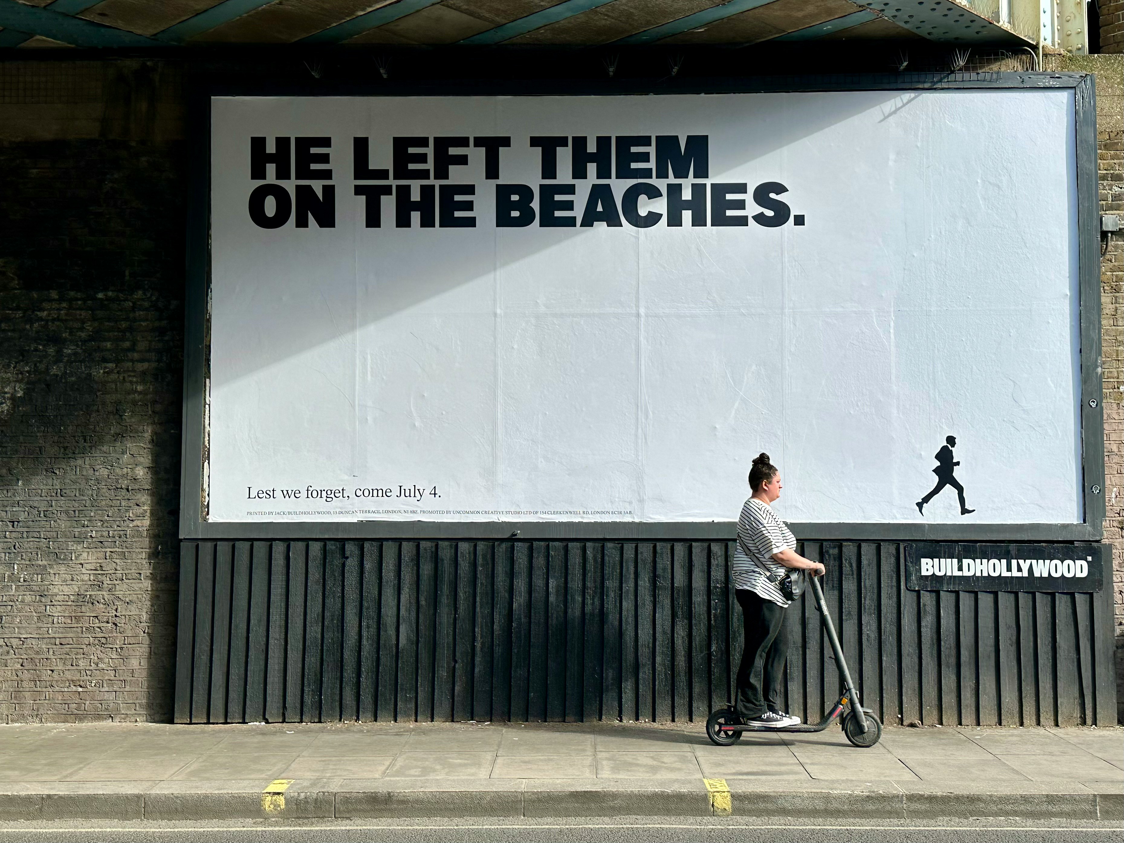 A man riding a scooter past a billboard