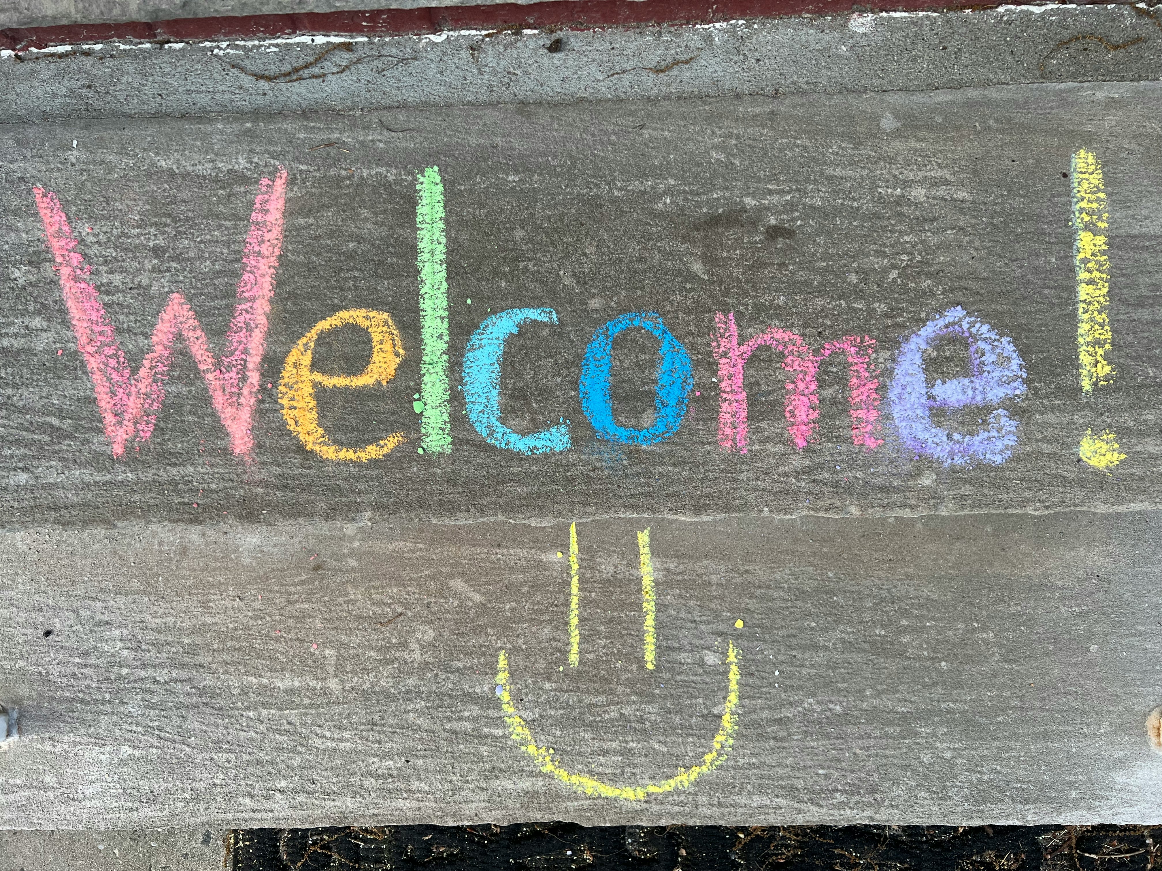 a welcome sign with a smiley face drawn on it