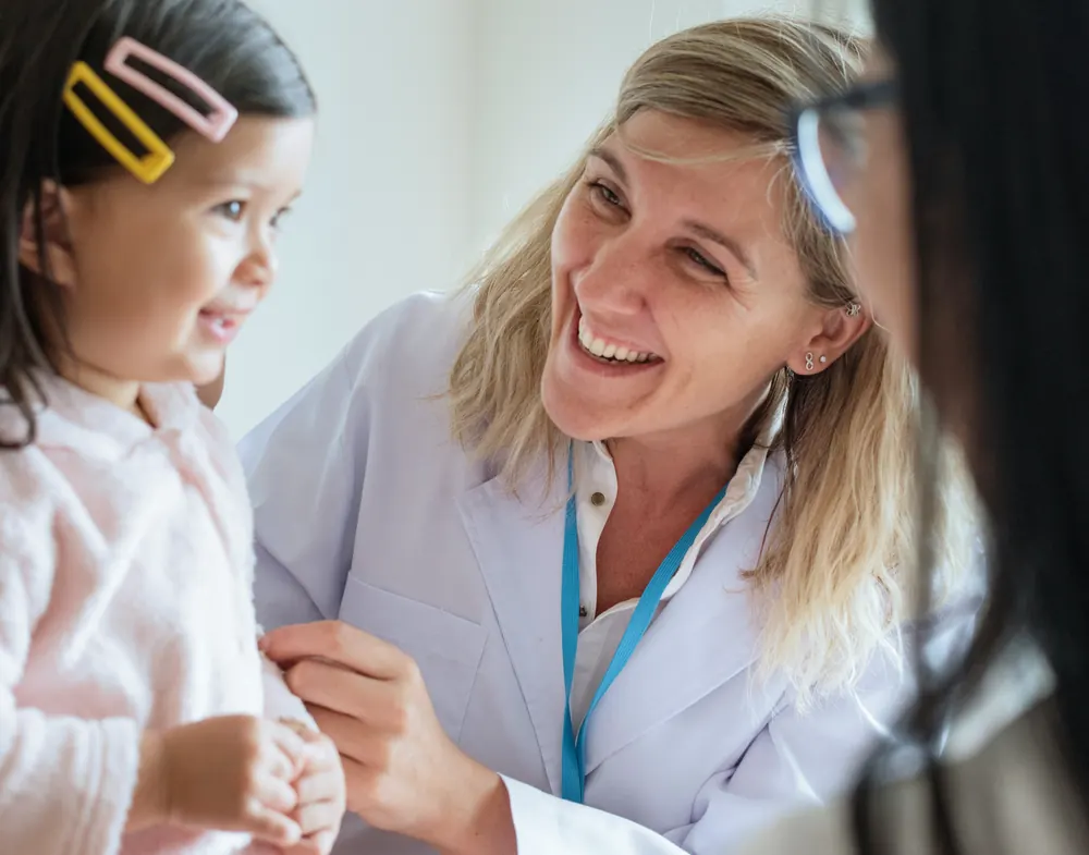 Paediatrician smiling at a little girl during a check-up