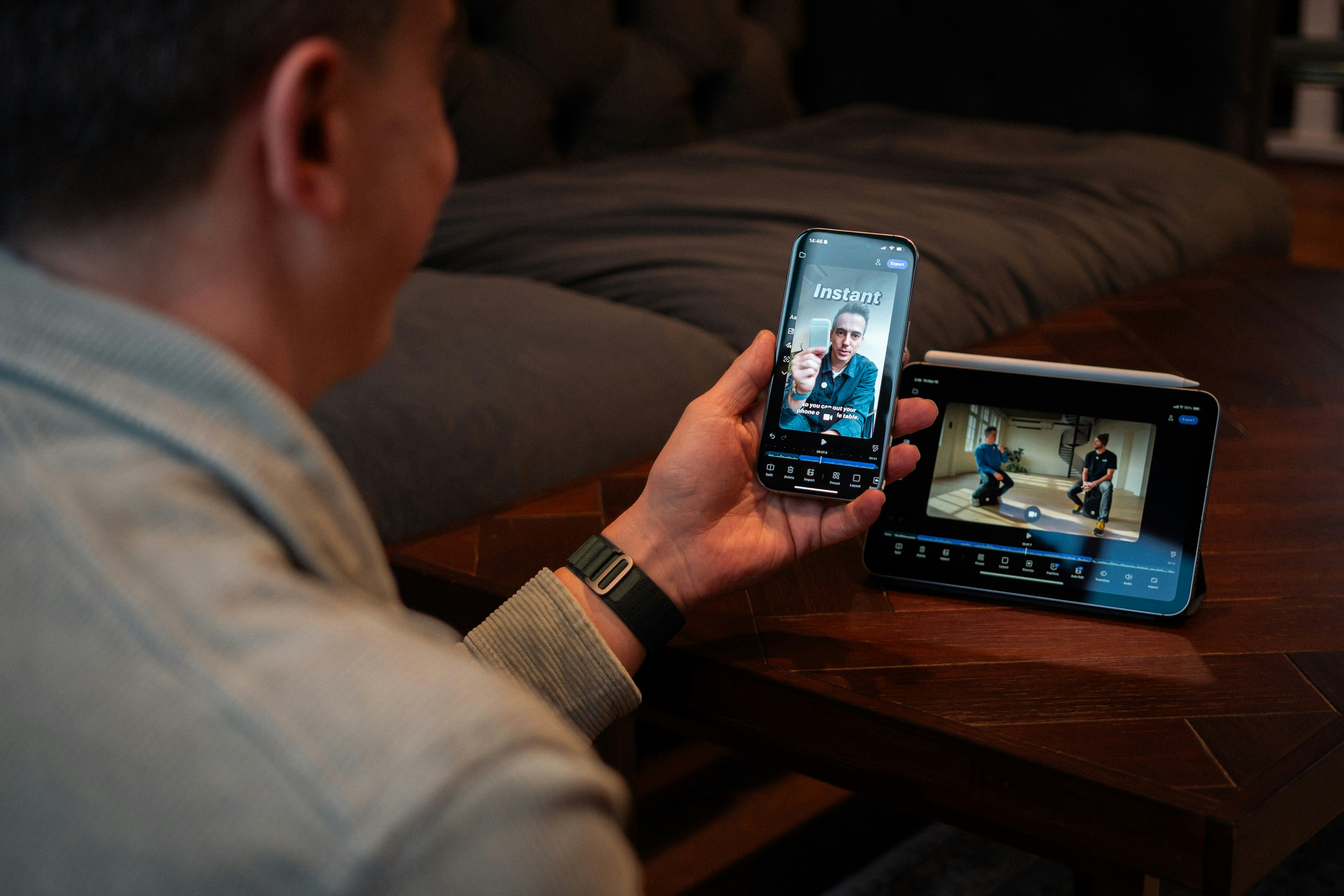 Man holding phone watching video on screen.