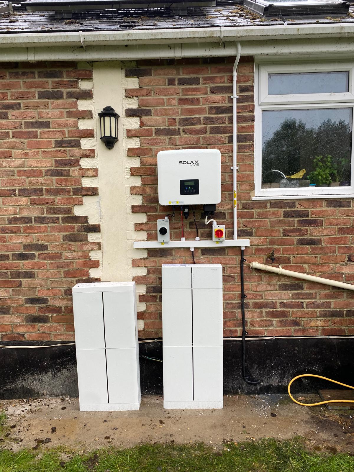 Inverter and two battery units mounted on the outside wall at Peter's home