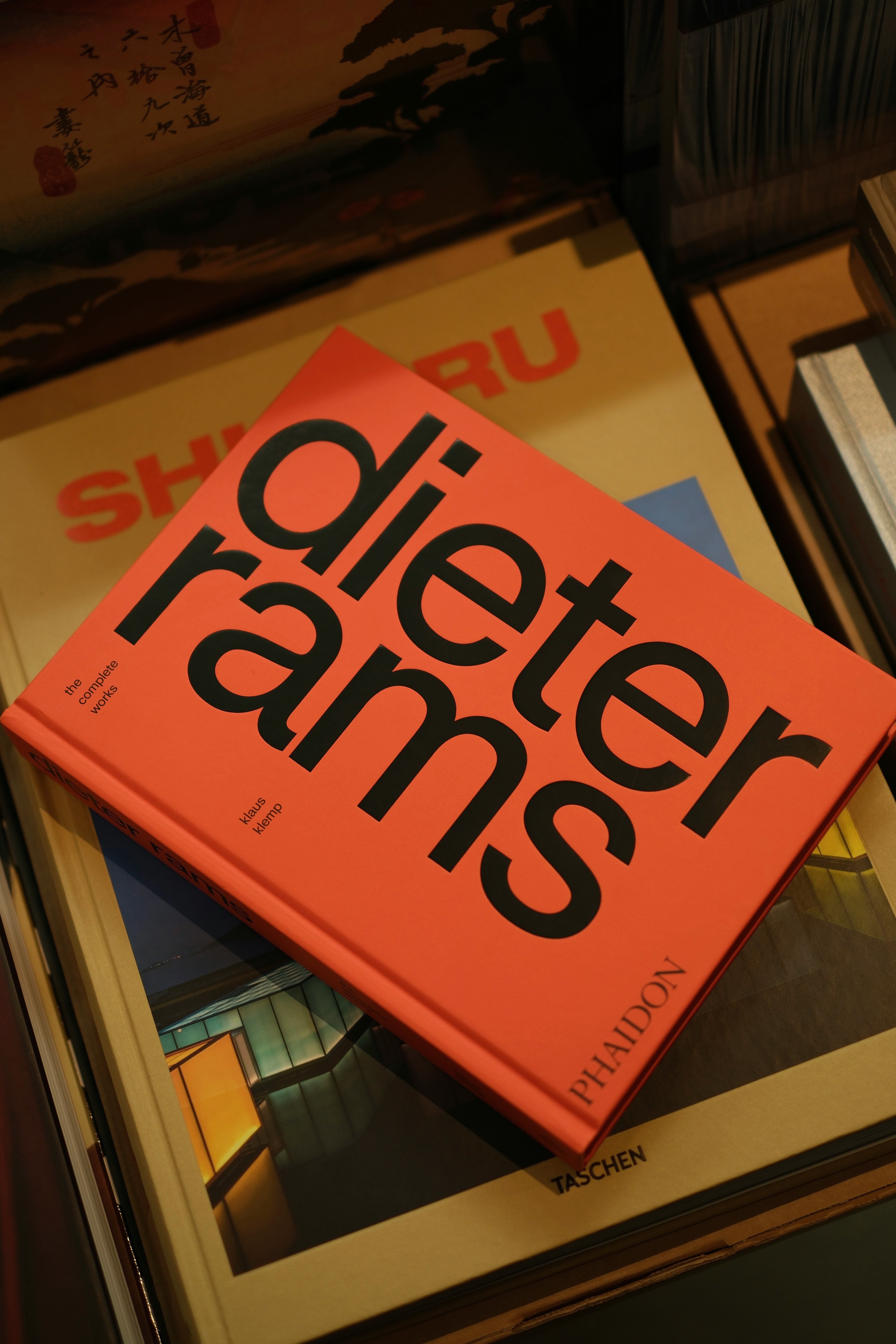 Orange book titled "dieter rams" on top of other books.