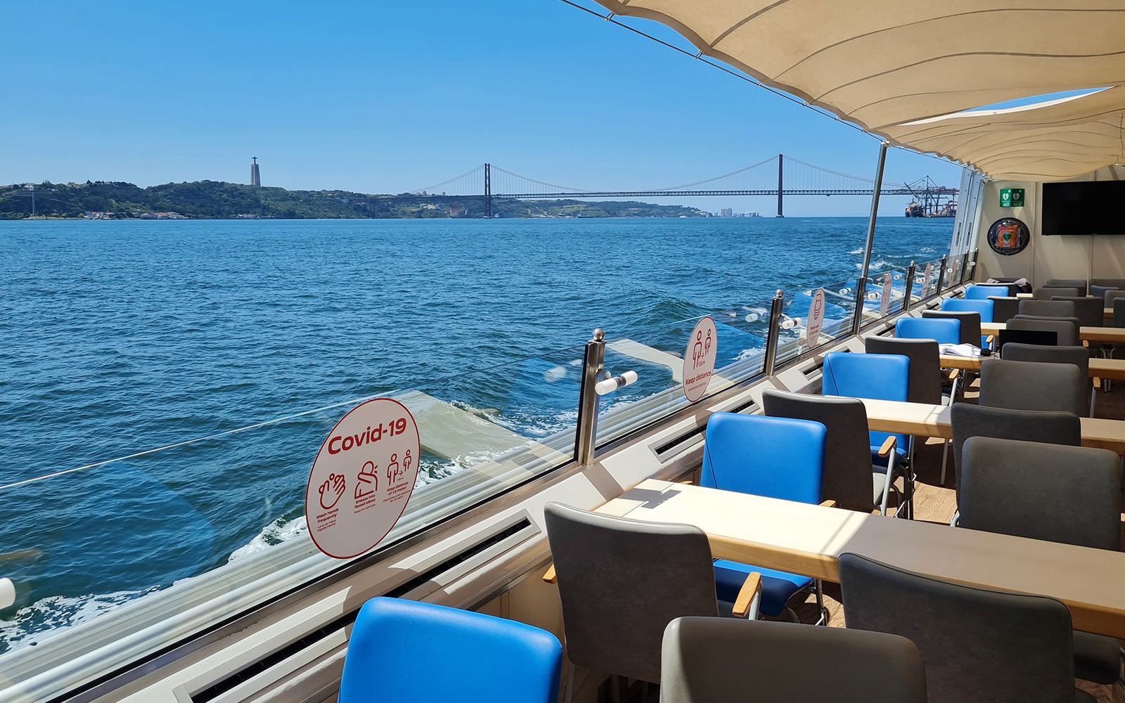 Interior of a boat on the Tagus River with views of the 25 de Abril Bridge in Lisbon.