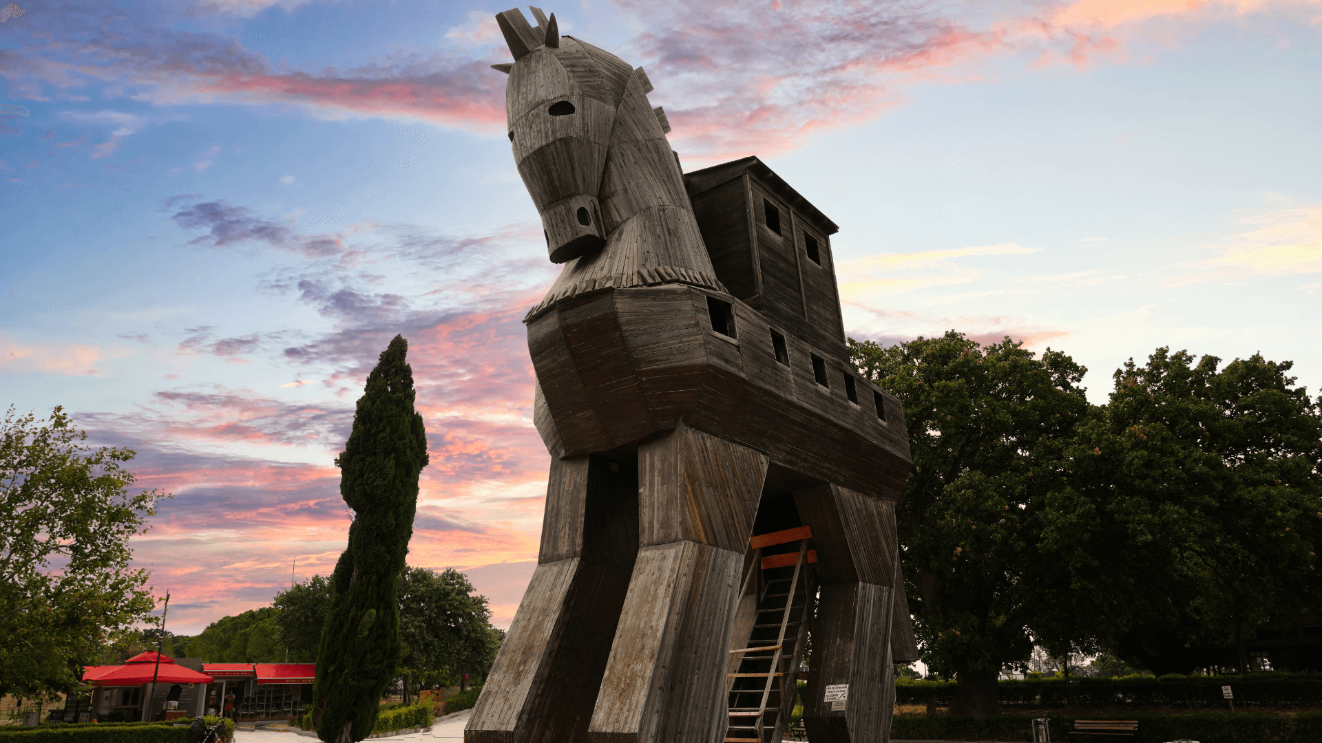 Replica of the legendary Trojan Horse in Troy, Türkiye — A large wooden structure set against a colorful sunset sky.