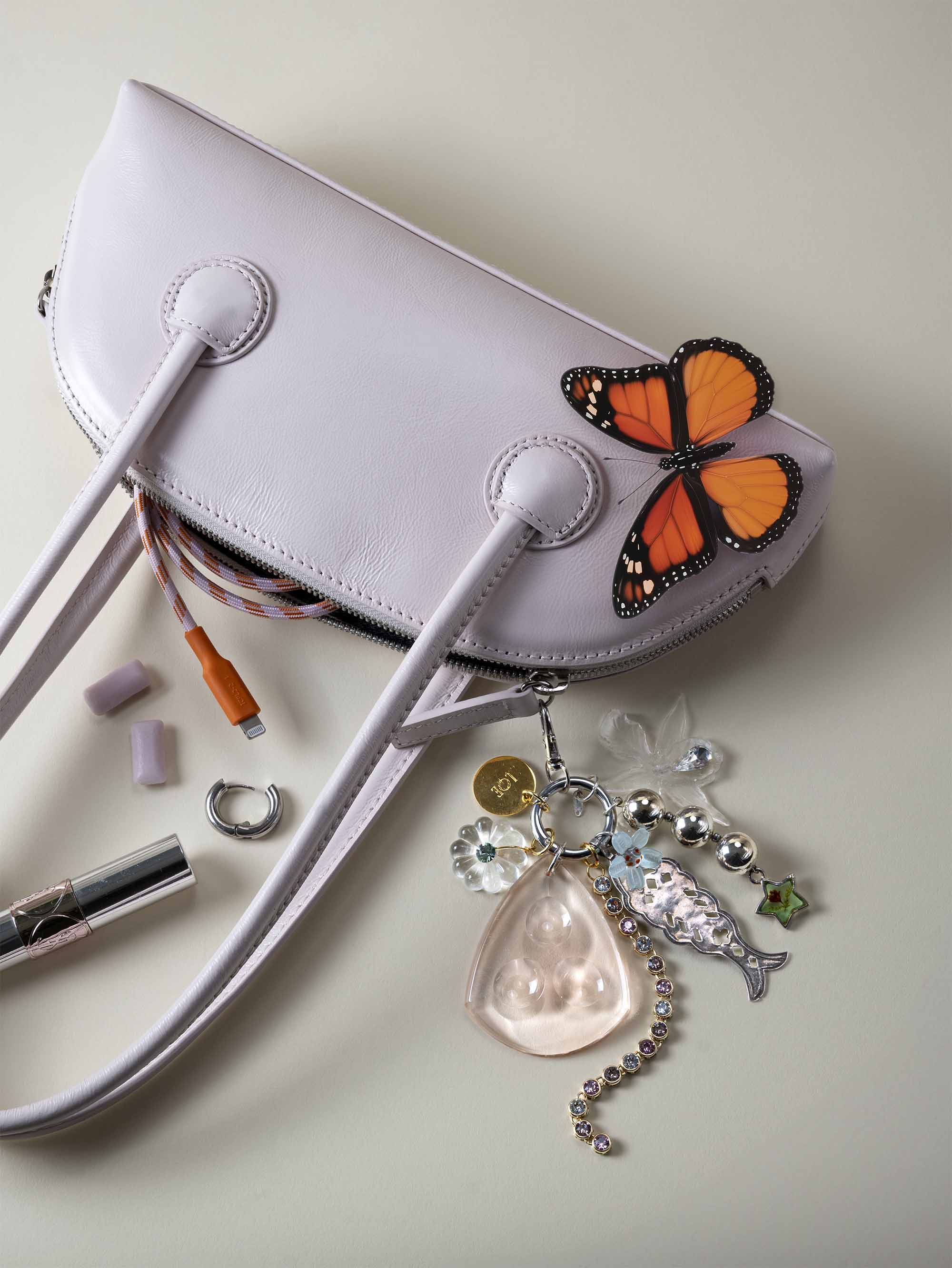 shooting photo bijoux de sac haute fantaisie accrochés à un sac à main bleu pour campagne de marque marseille