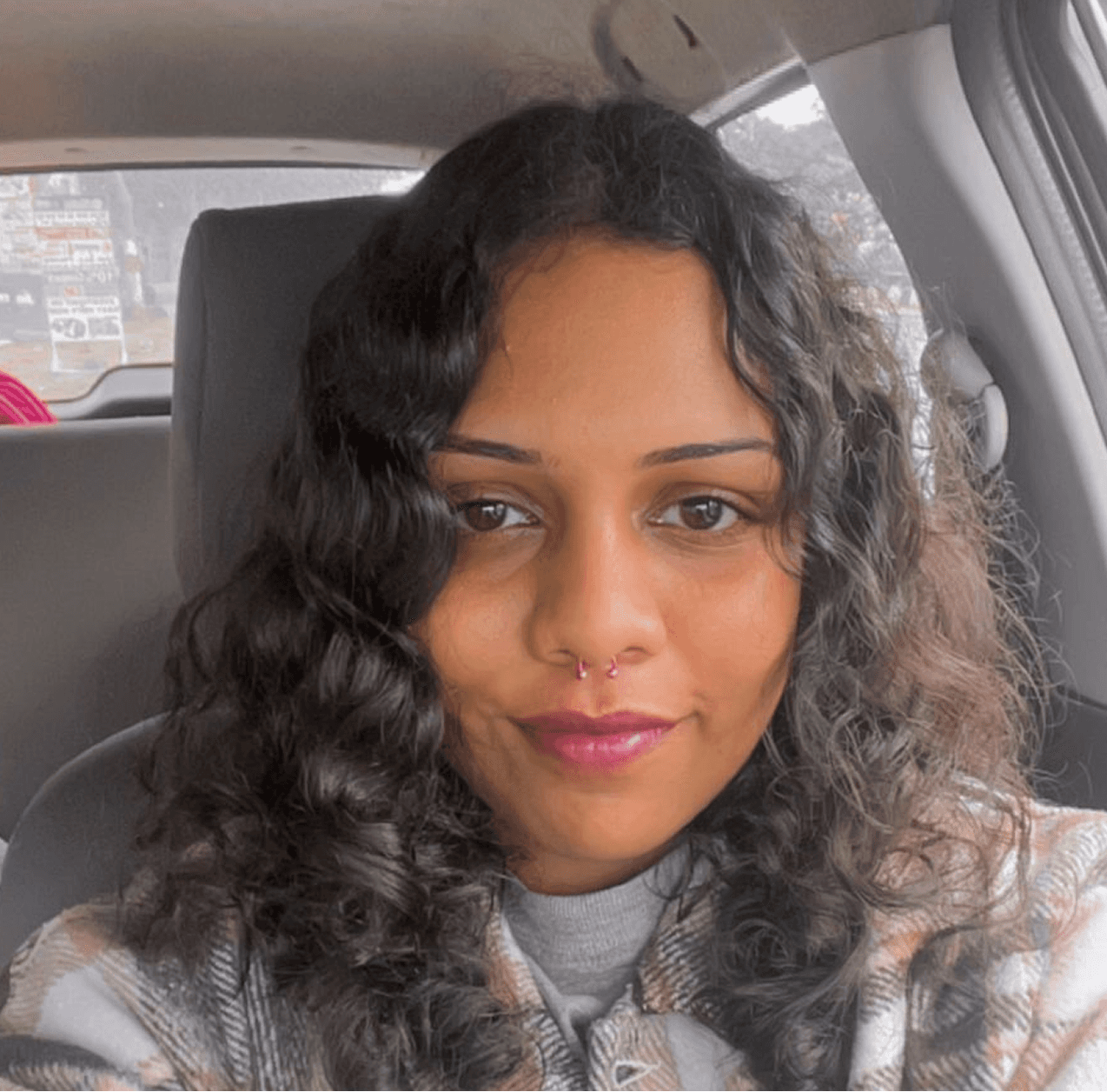 A businesswoman sitting at her desk, smiling and looking at the camera.