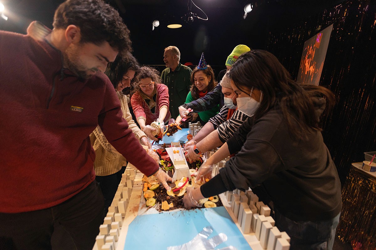 Audience members help clean up the miniature city.