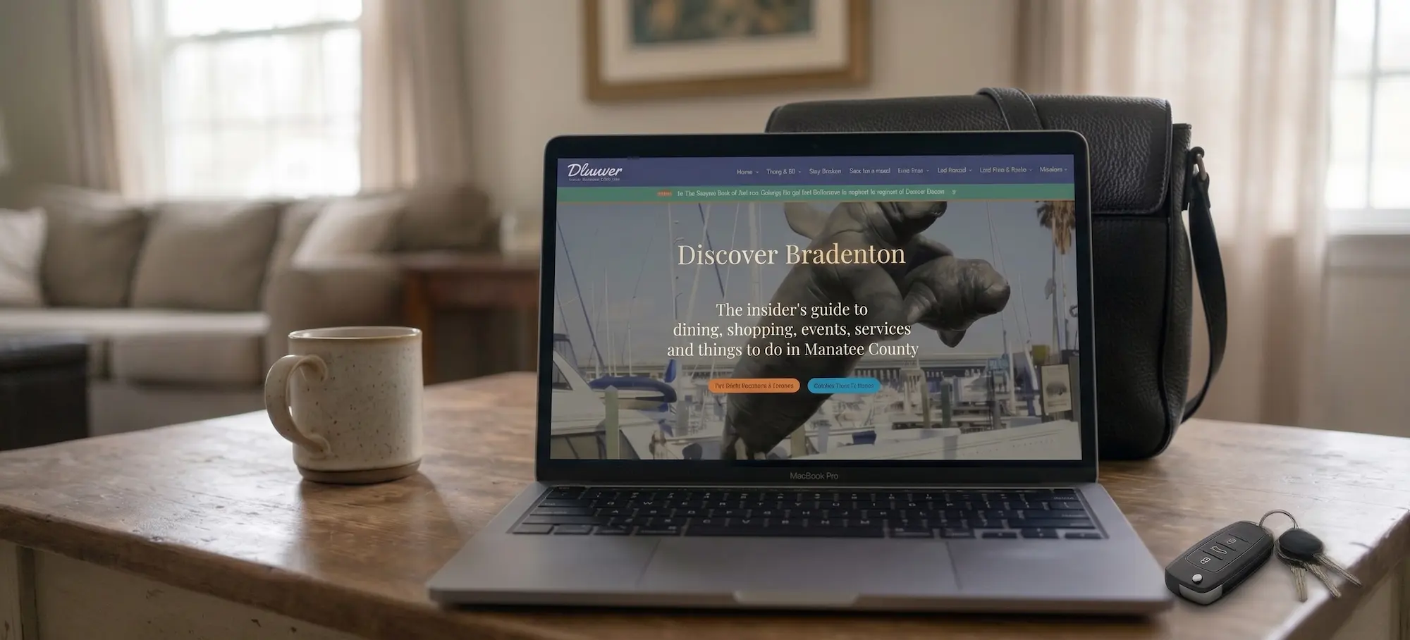 a laptop onen on a table with discover bradenton website on the screen