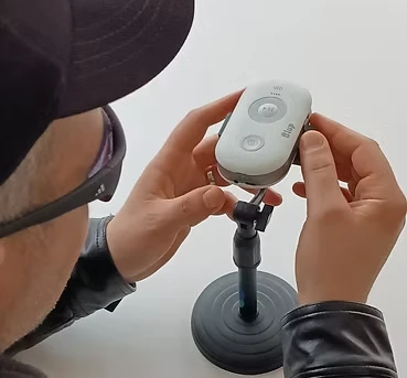 Persona colocando la Lupa Inteligente en su soporte de mesa