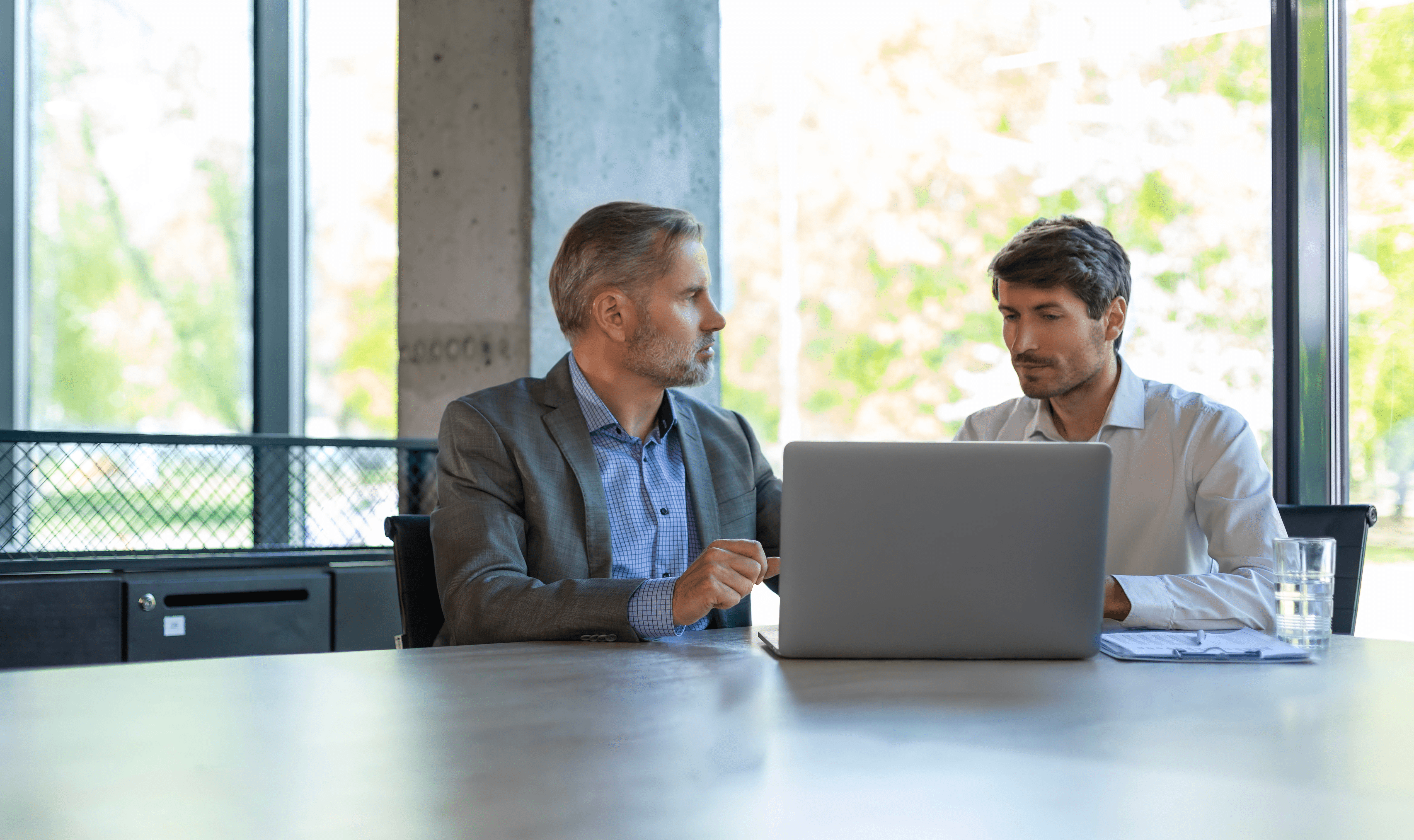 Auditor überprüft die Leistung des Lieferanten mit einem Dienstleister in einer Besprechungssituation, was die Prüfung von Lieferanten- und ausgelagerter Prozessverwaltung, Vertragskontrollen im Vergleich zur operativen Realität und die Sicherstellung über organisatorische Grenzen hinweg darstellt.