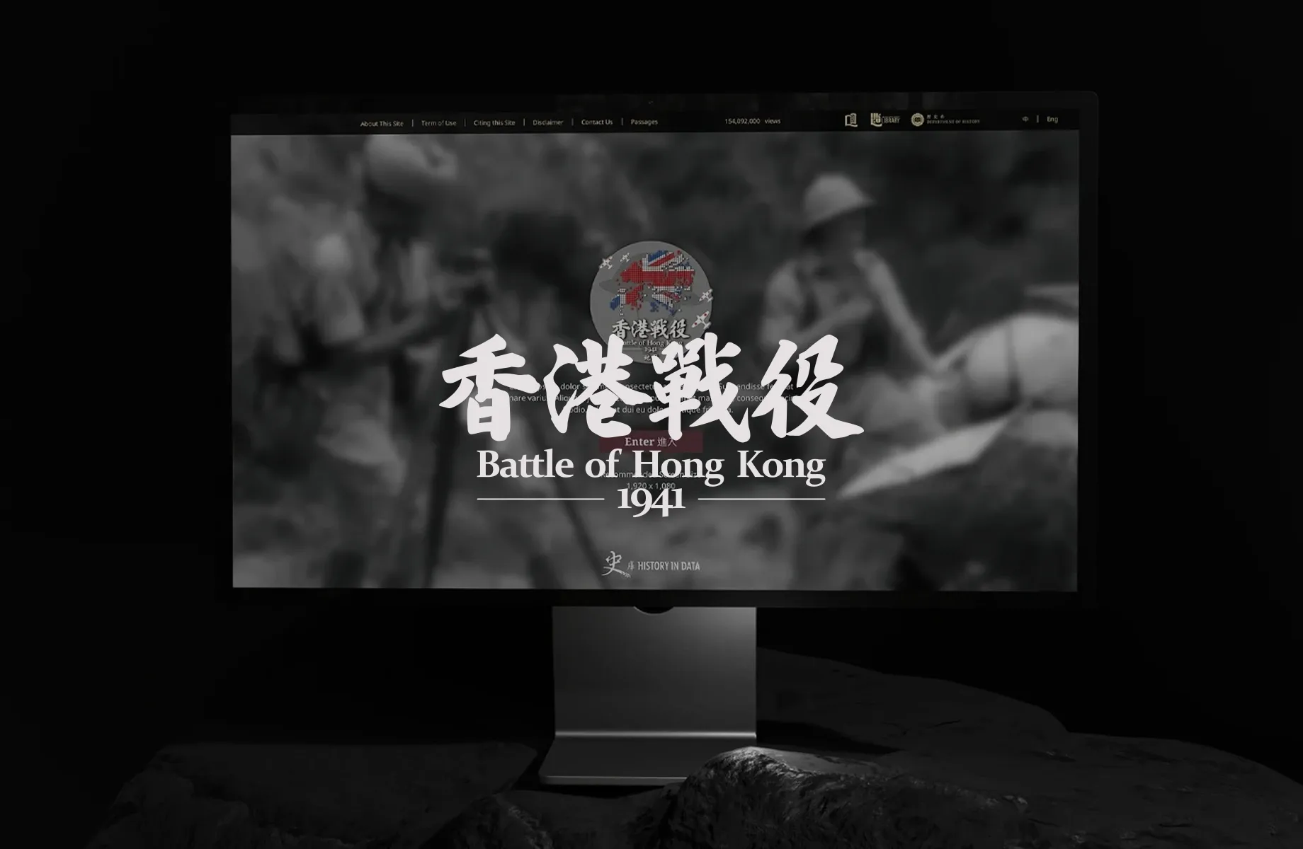 The Battle of Hong Kong 1941 spatial history project – computer screen displaying black-and-white wartime imagery with Chinese title overlay and British flag emblem, designed by Teatime Studio for HKBU History Department.