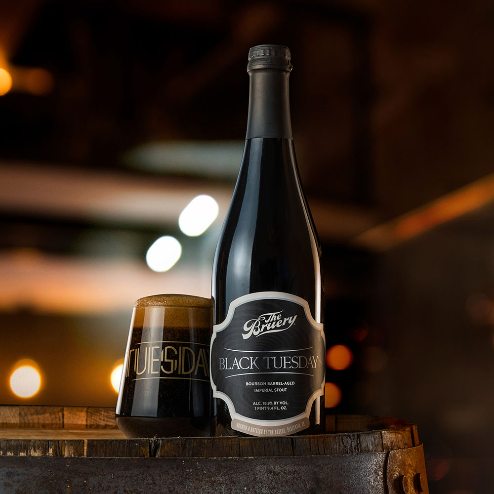 Black Tuesday glass and bottle close-up with warm lighting