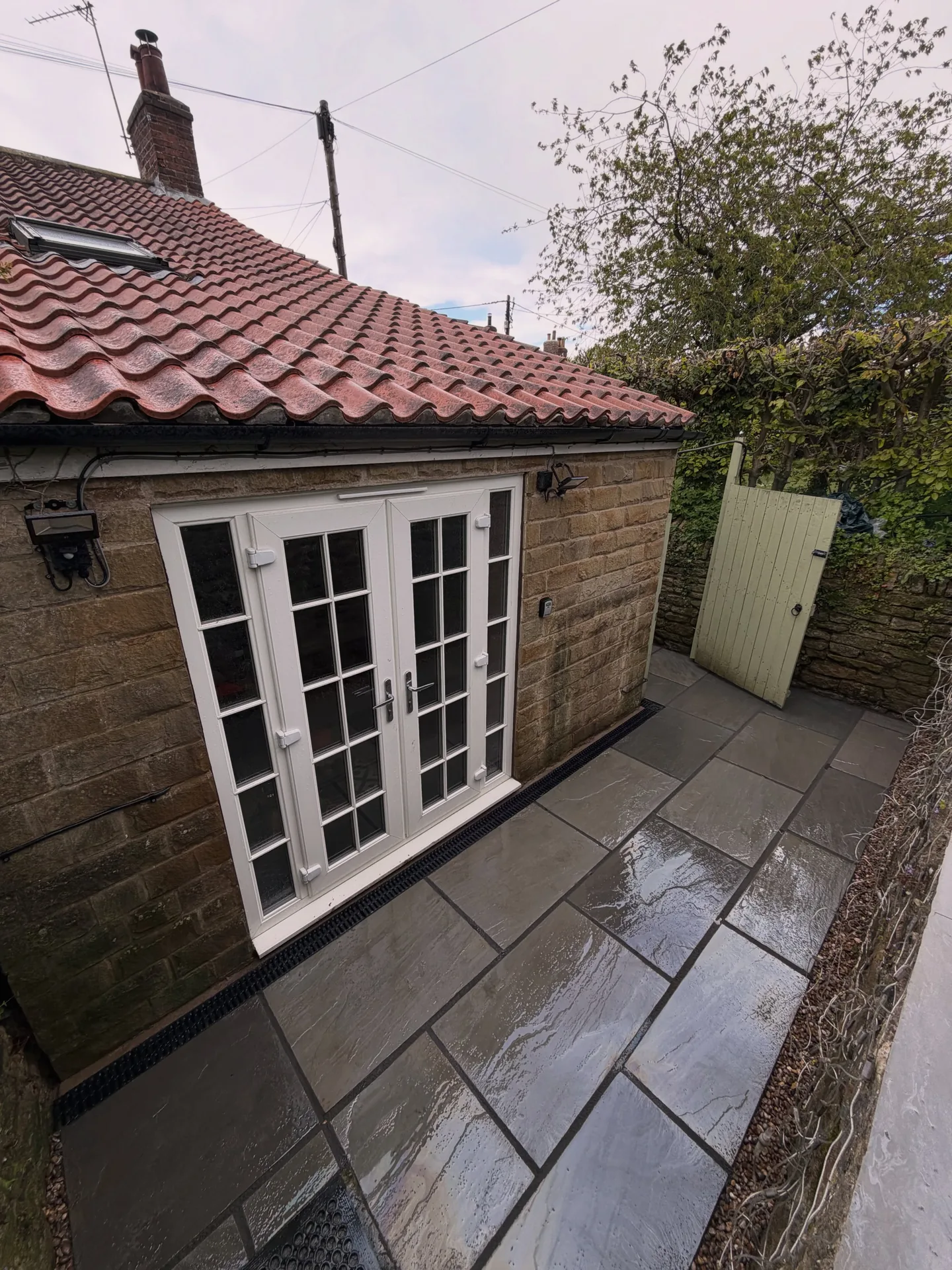 Finished Indian stone paving with channel drainage beside the property