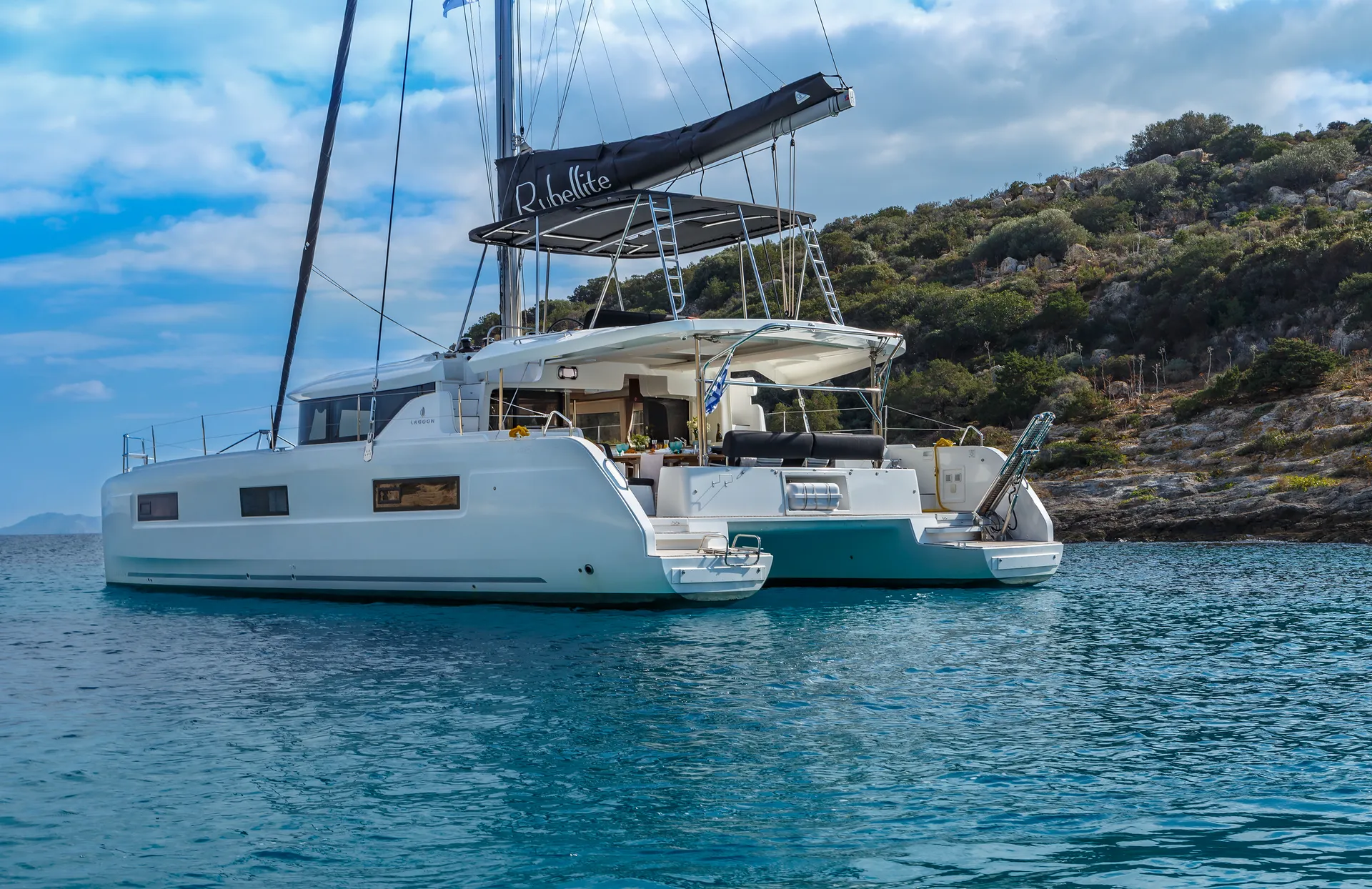 White Rock 36 speedboat with captain at helm cruising calm blue waters near Paros coastline with hills in background.