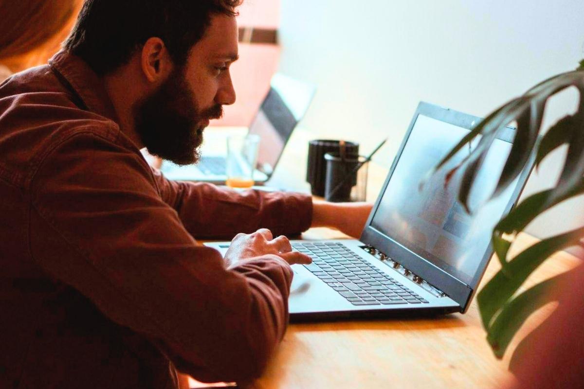 A person using a laptop at an office table.
