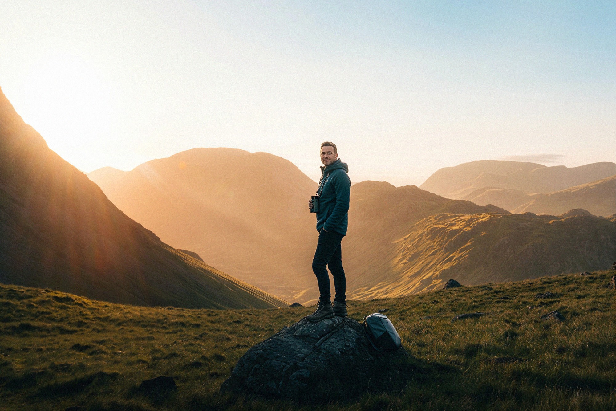 Man standing on mountain at sunrise representing clarity and confident decision making