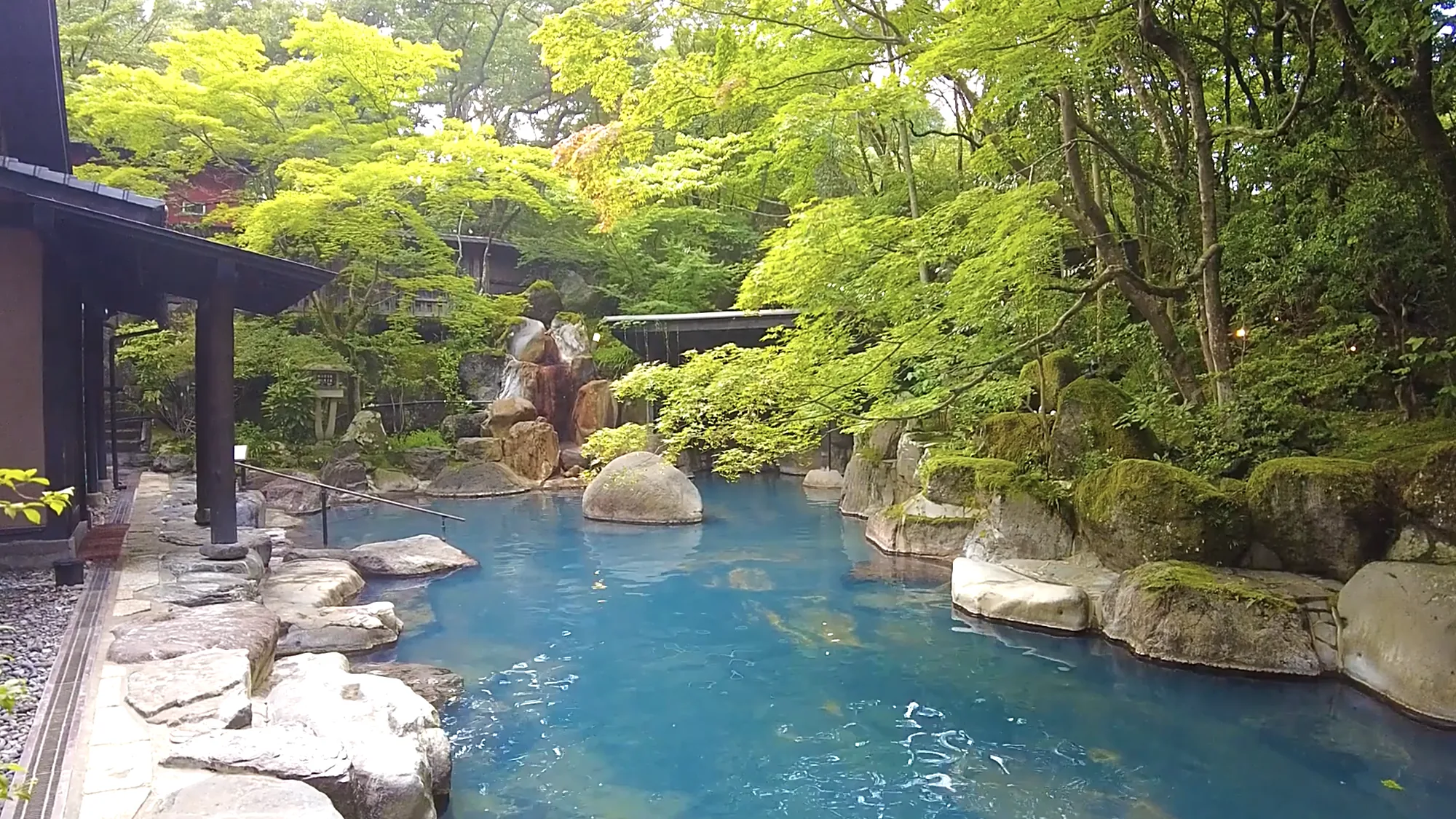 A large milky blue garden pool in summer