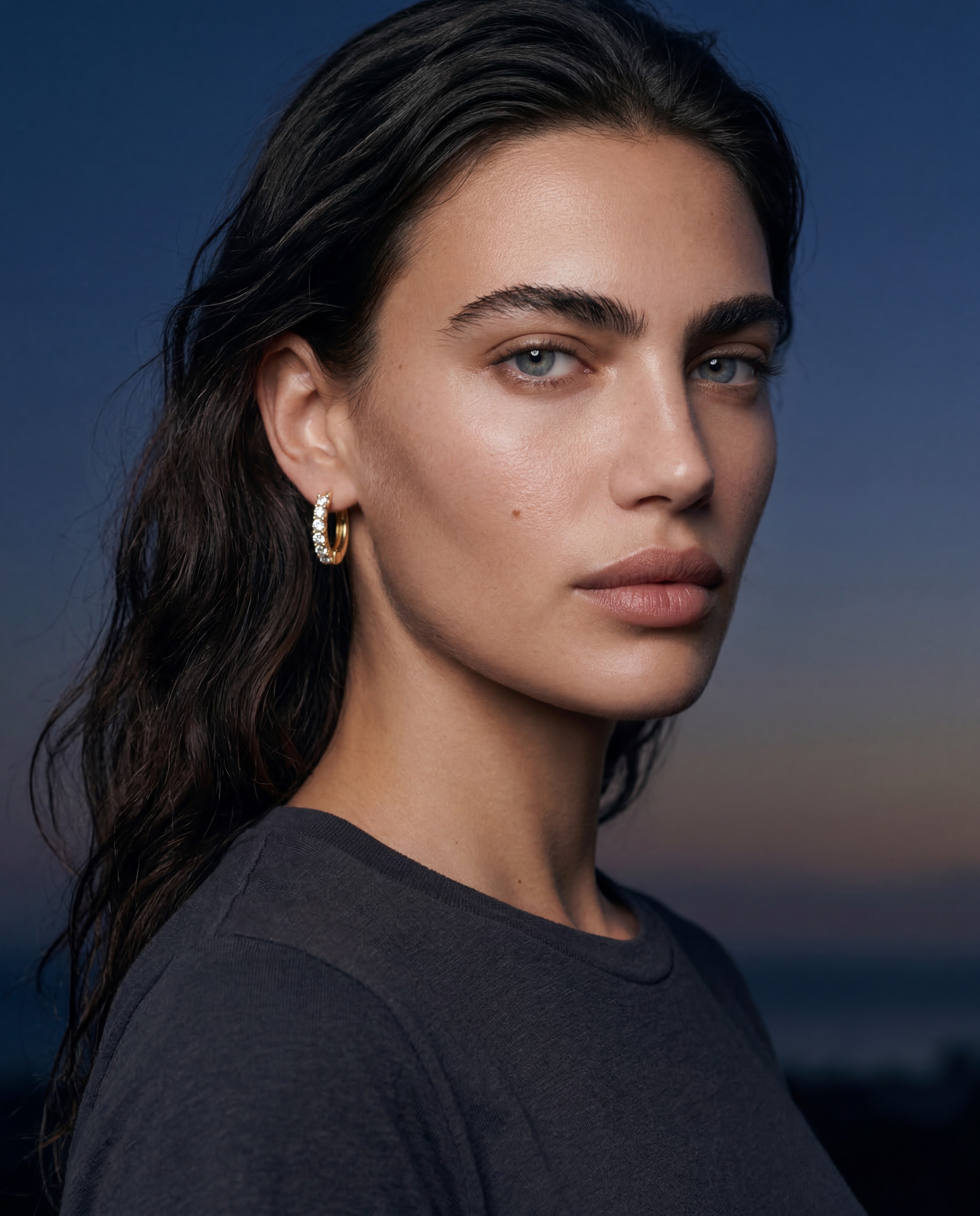 Mila Kovač AI model wearing gold earrings, dark editorial studio portrait, Gemzy AI jewelry studio
