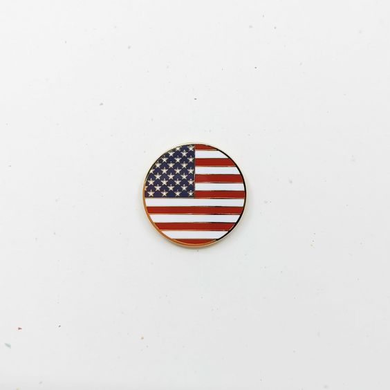 A circular pin with the design of the American flag