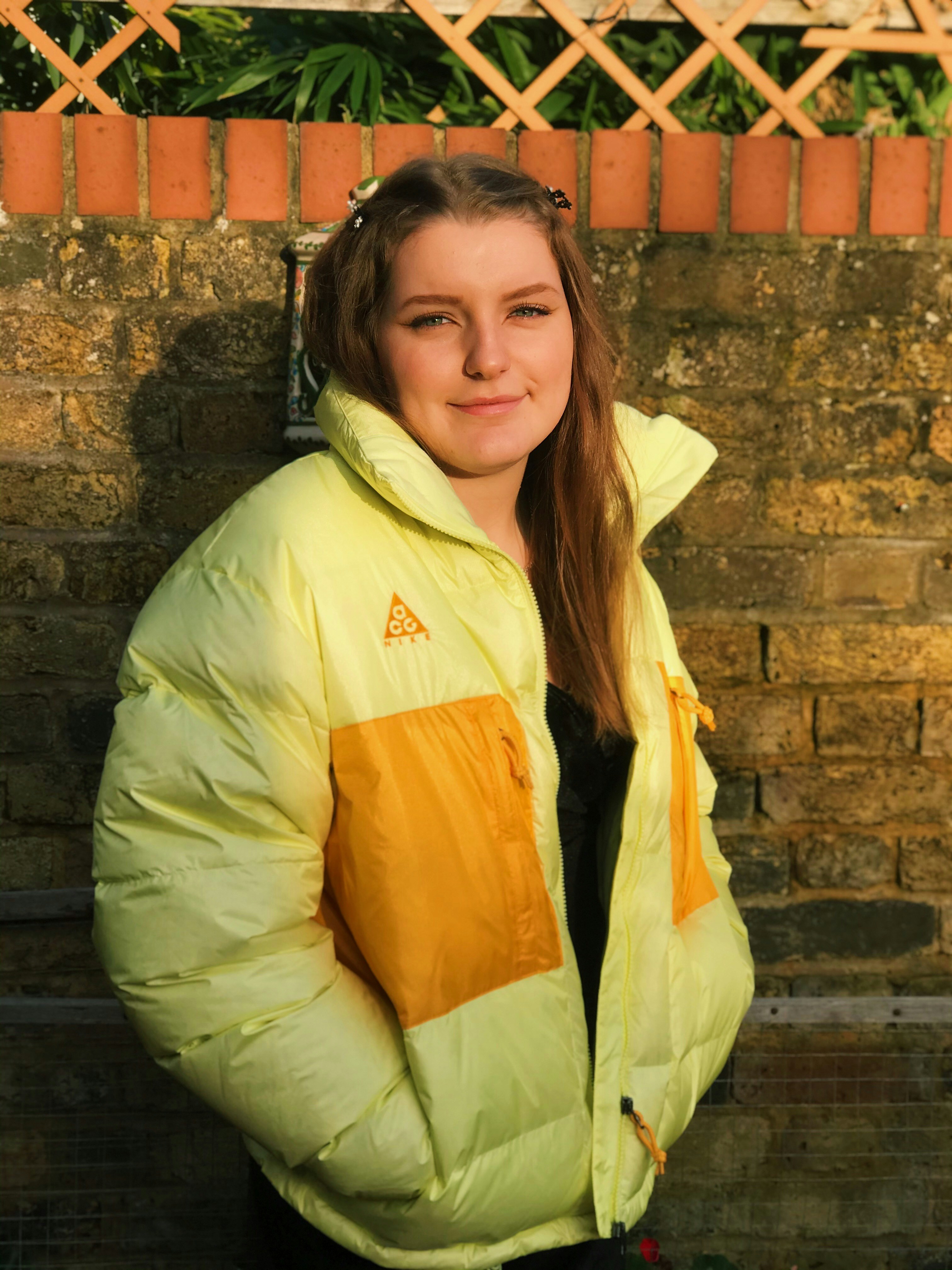 woman in green and yellow jacket smiling