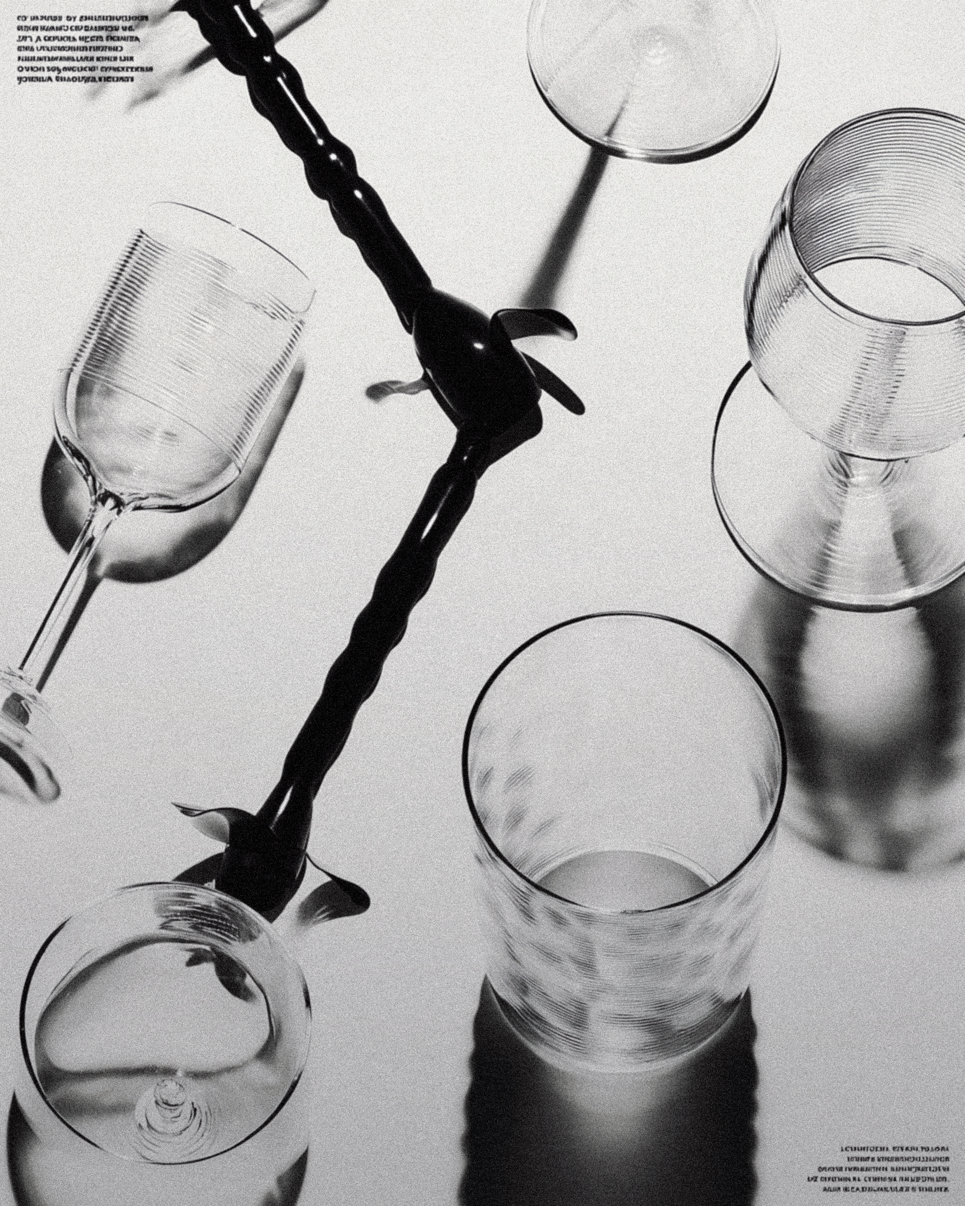 Glassware flat lay with a black stirring tool and crisp shadows