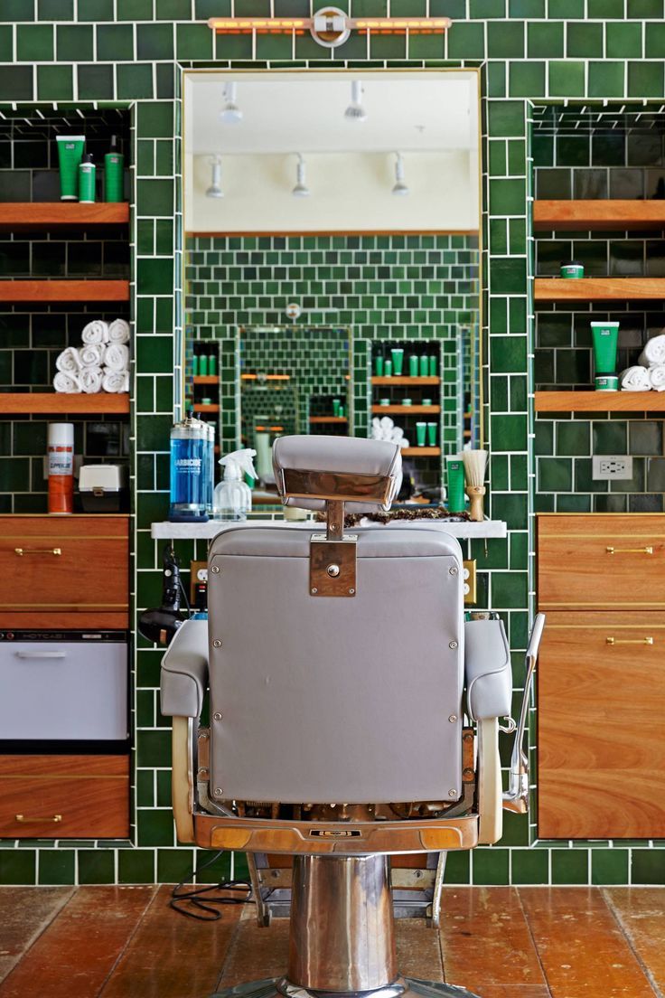 Smiling female therapist with short gray hair, wearing a brown top and a purple shawl, surrounded by a cozy background.