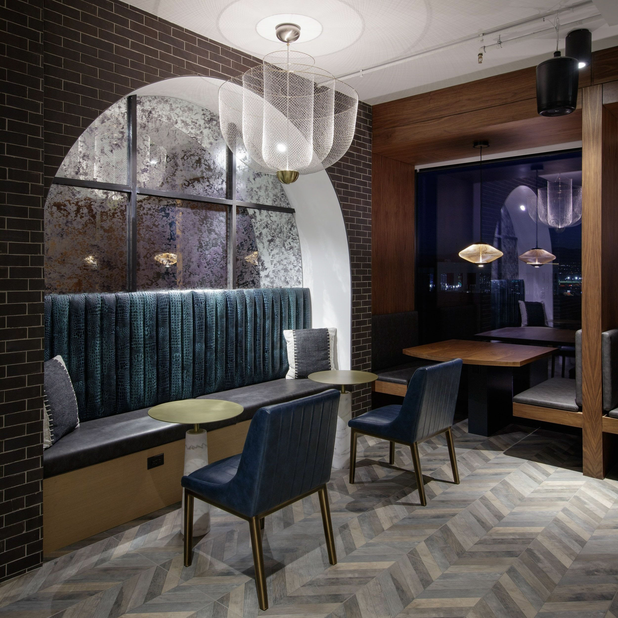 Modern cafe with dark tiling, bench seating, and contemporary lights.