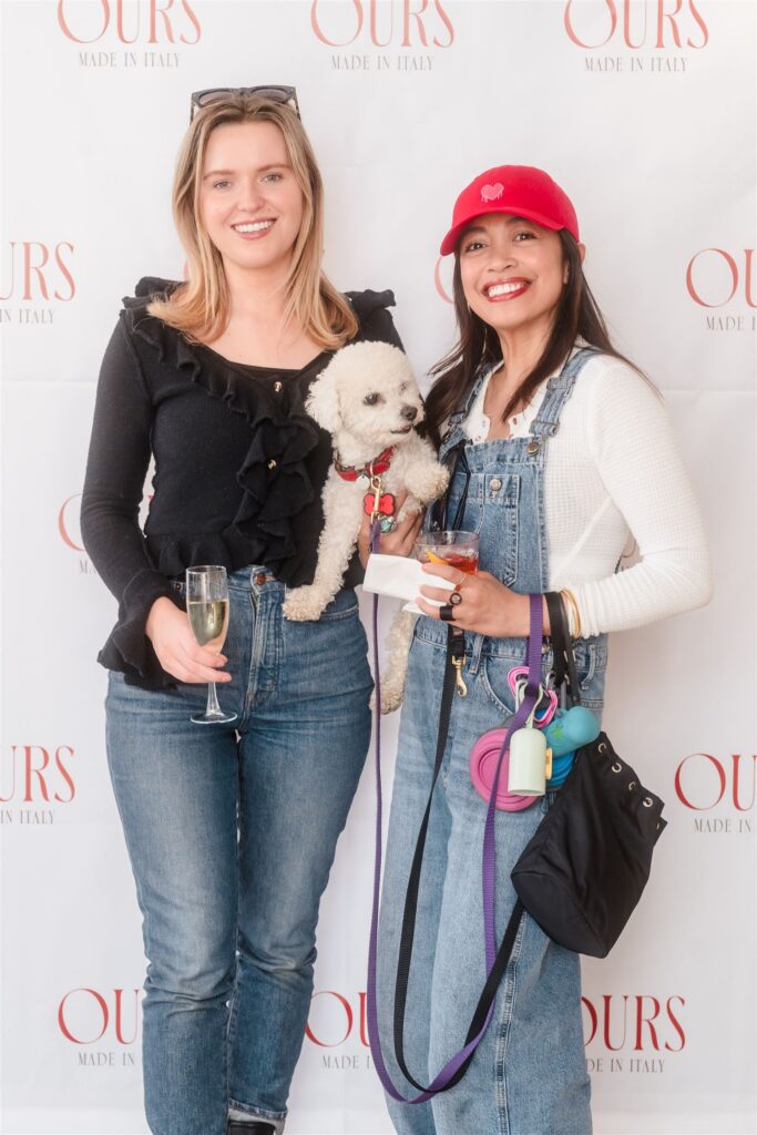Event guests smiling with a small white dog and cocktails, illustrating a pet-friendly and upscale atmosphere for a curated brand activation.