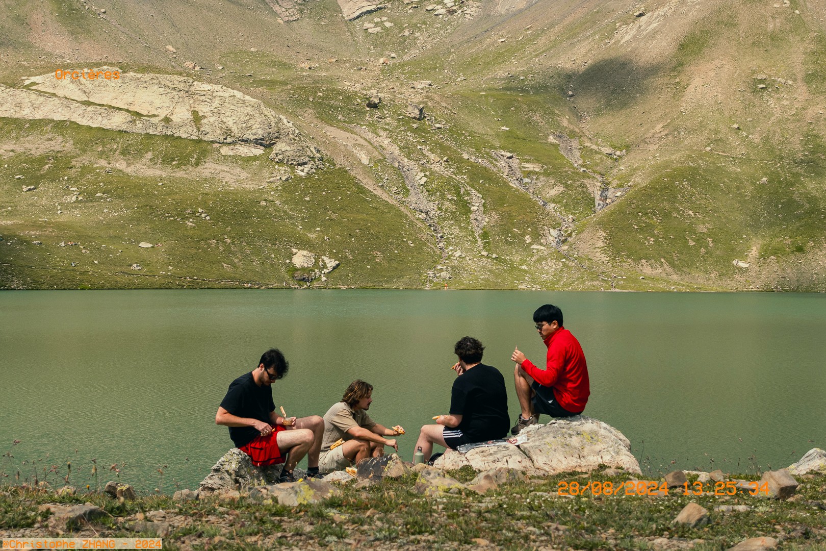 Groupe d’amis mangeant au bord du Grand Lac des Estaris à Orcières.
