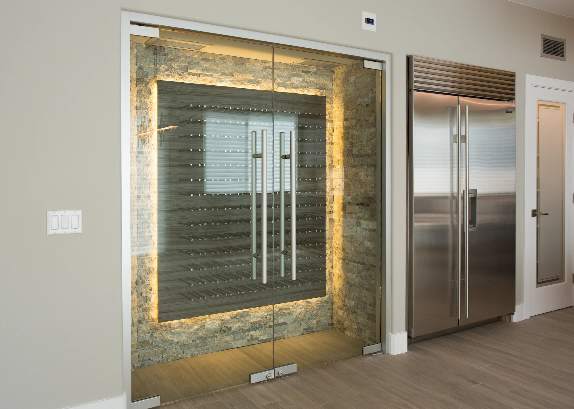 Wide shot of the Sub Zero fridge and wine cellar doors, highlighting the custom-built, temperature-controlled features in this contemporary kitchen.