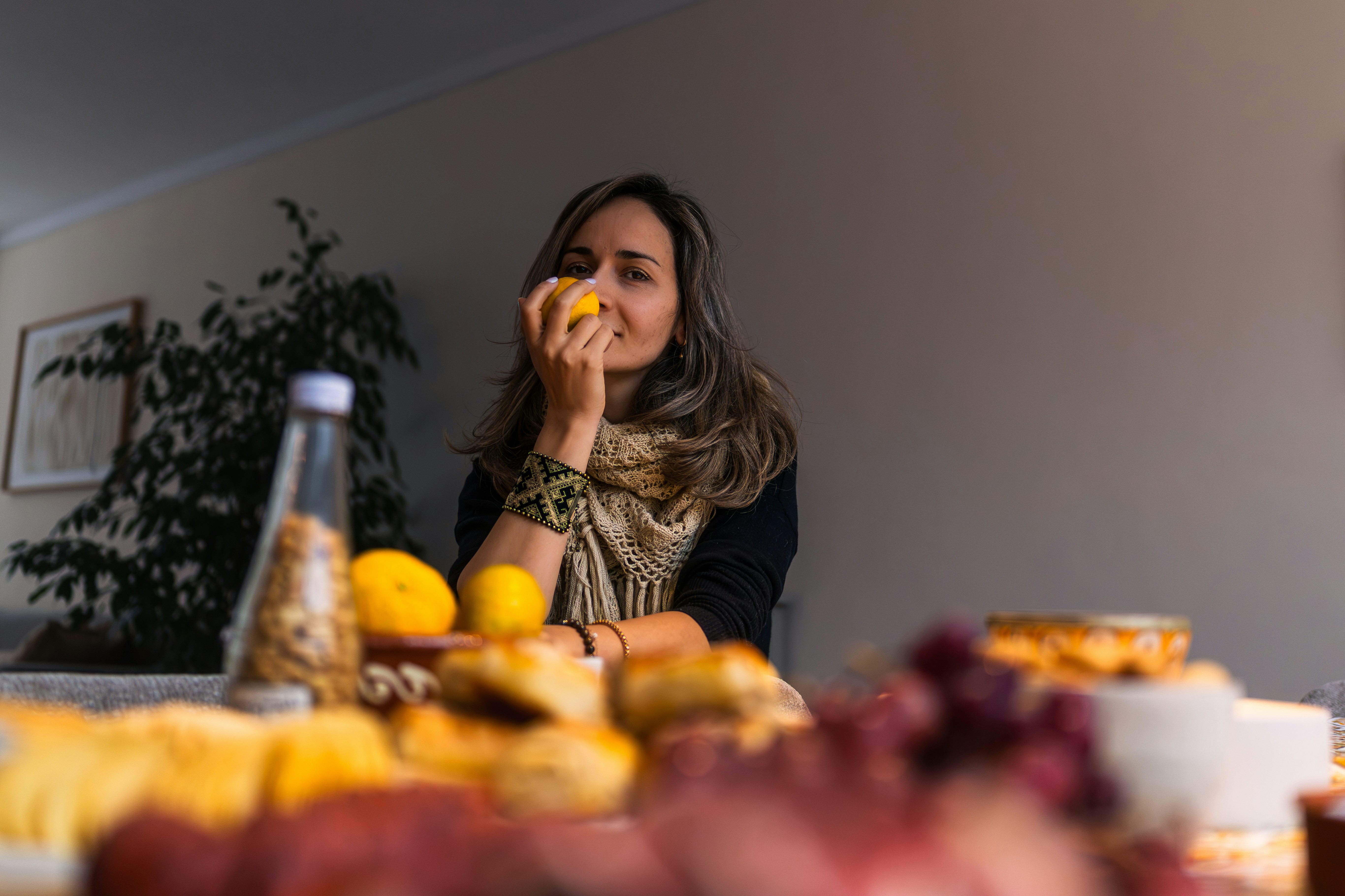 Woman smelling a lemon at a table with food