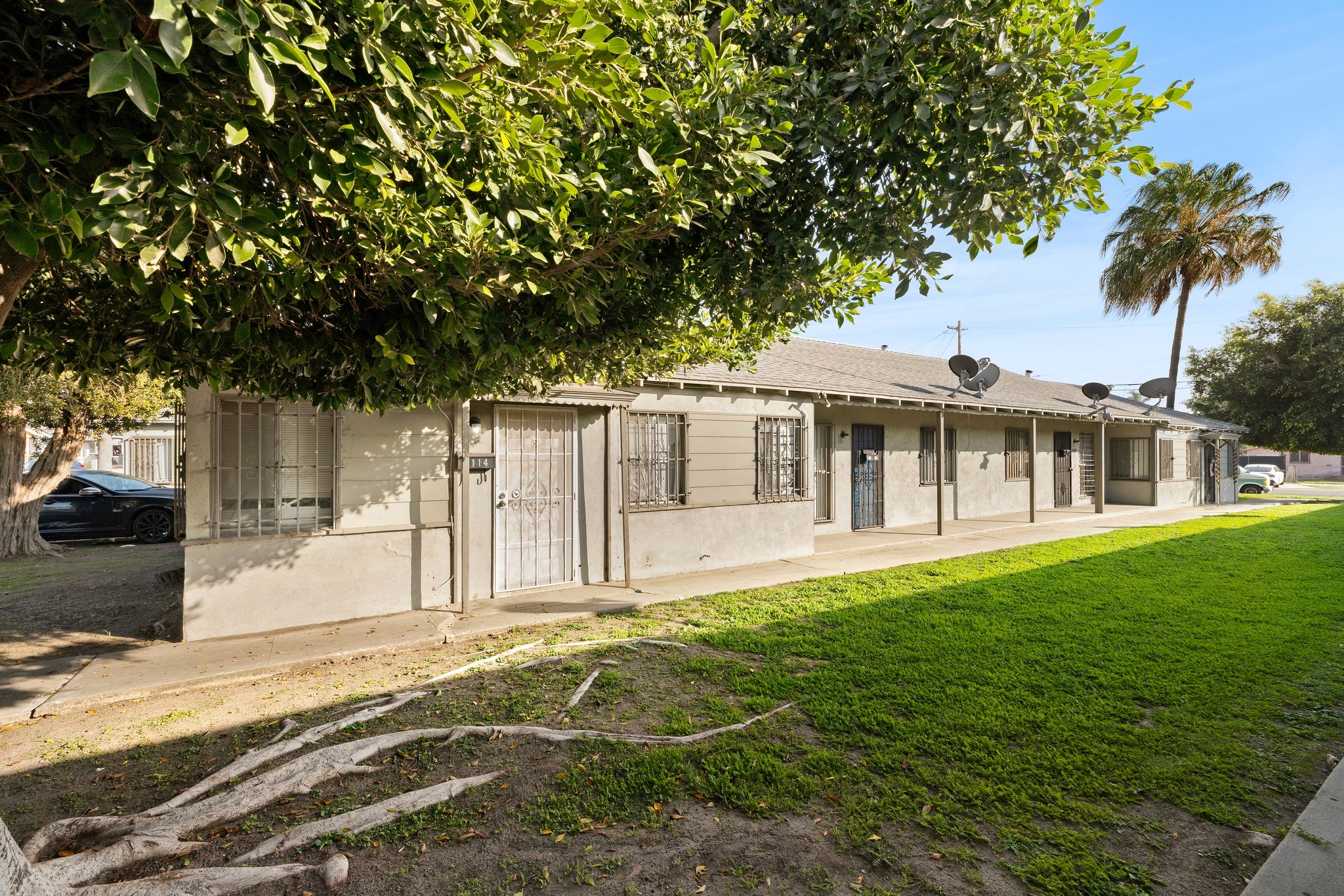 Exterior side elevation of 1105 E Hyde Park with green space and pathway access.