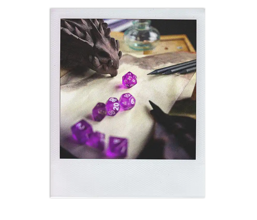 Close-up of colorful dice next to a model dragon head at a Spellbonding Adventures workshop