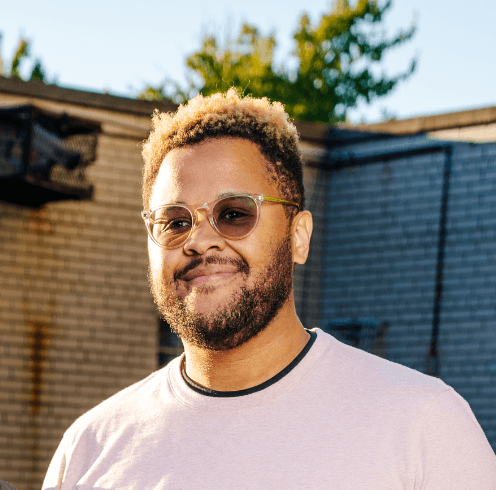 Scientist using a multi-channel pipette to transfer liquid samples in a lab, wearing gloves and surrounded by lab equipment.