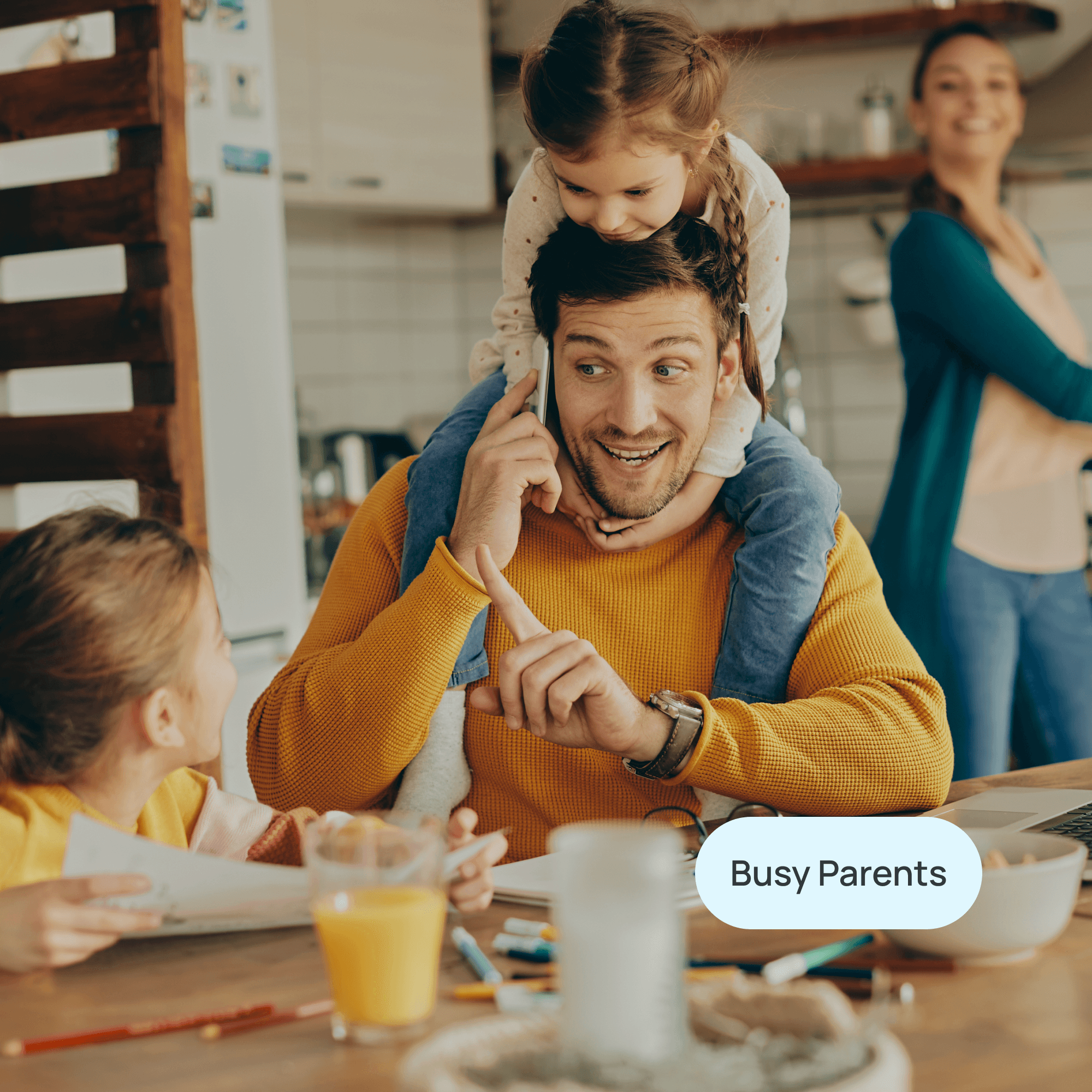 man with kids at the breakfast table with wife in the distance and label "busy parents"