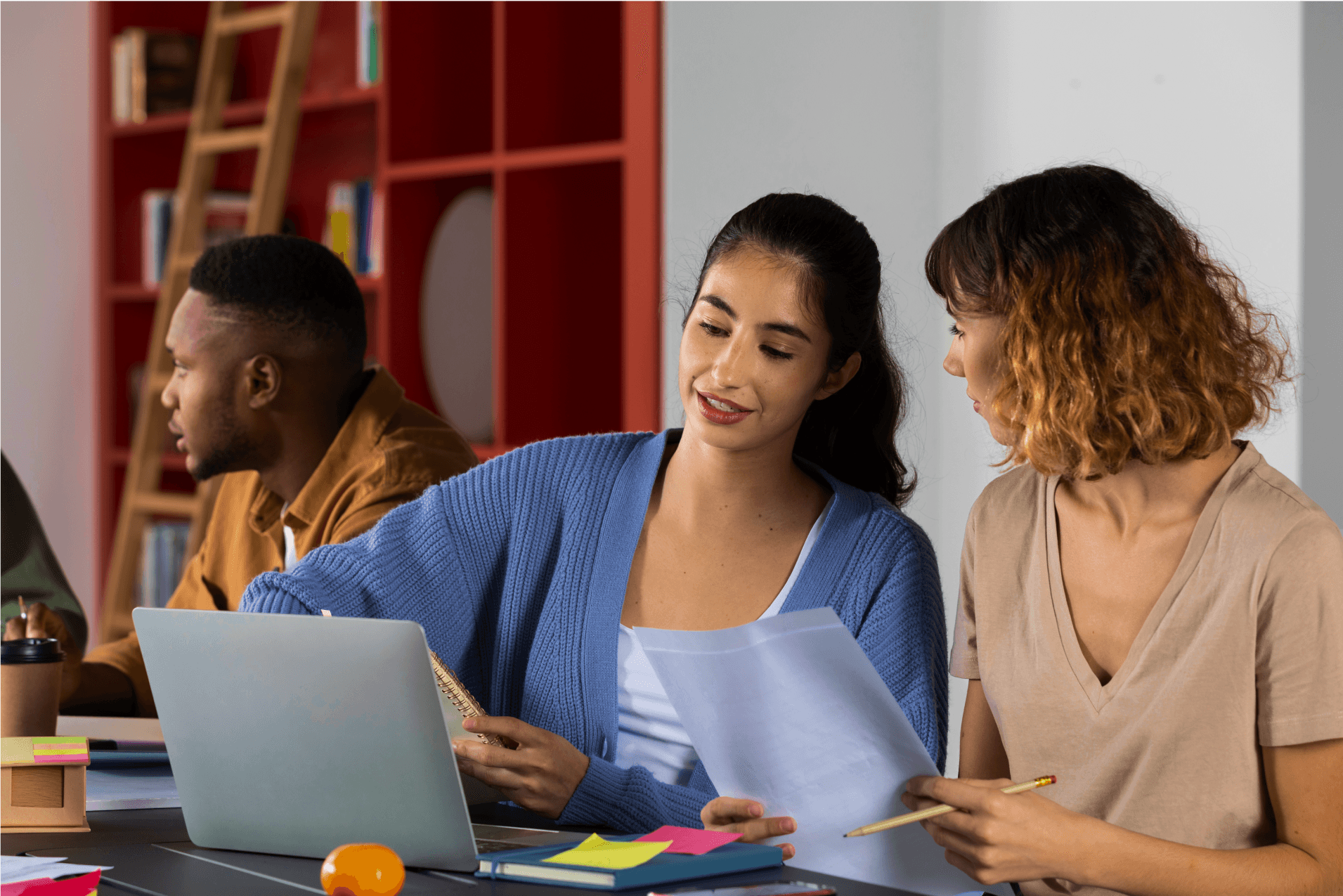 Photo of two ladies sitting together with one of them showing them something on their laptop.