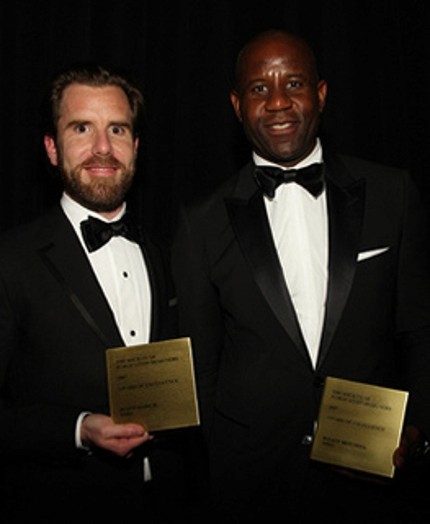 portrait of two men in black suits and white shirts