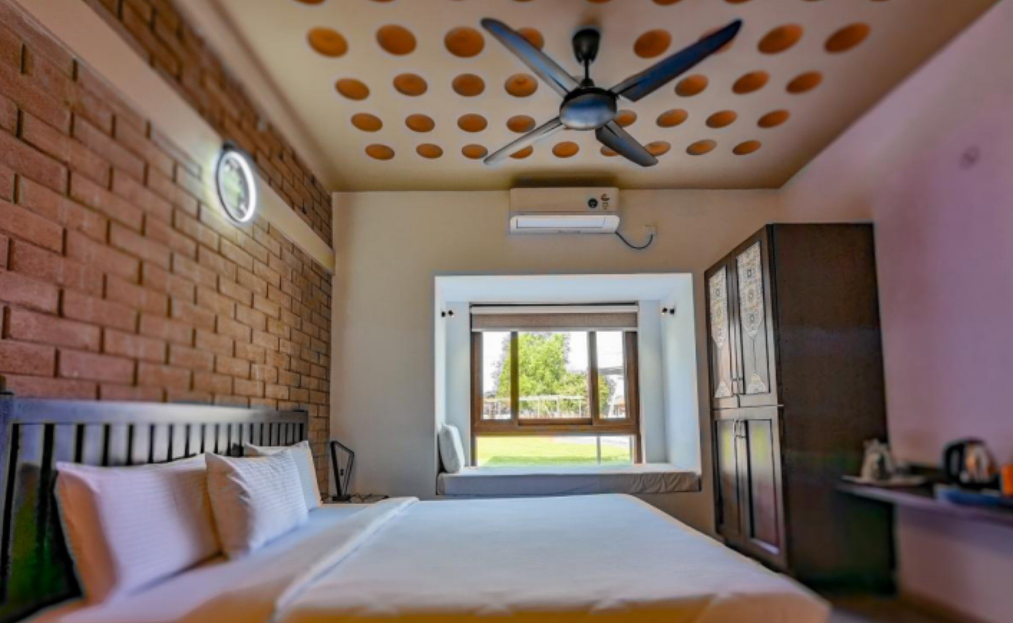 Group of hikers walking through a mountain meadow surrounded by pine trees and misty peaks.