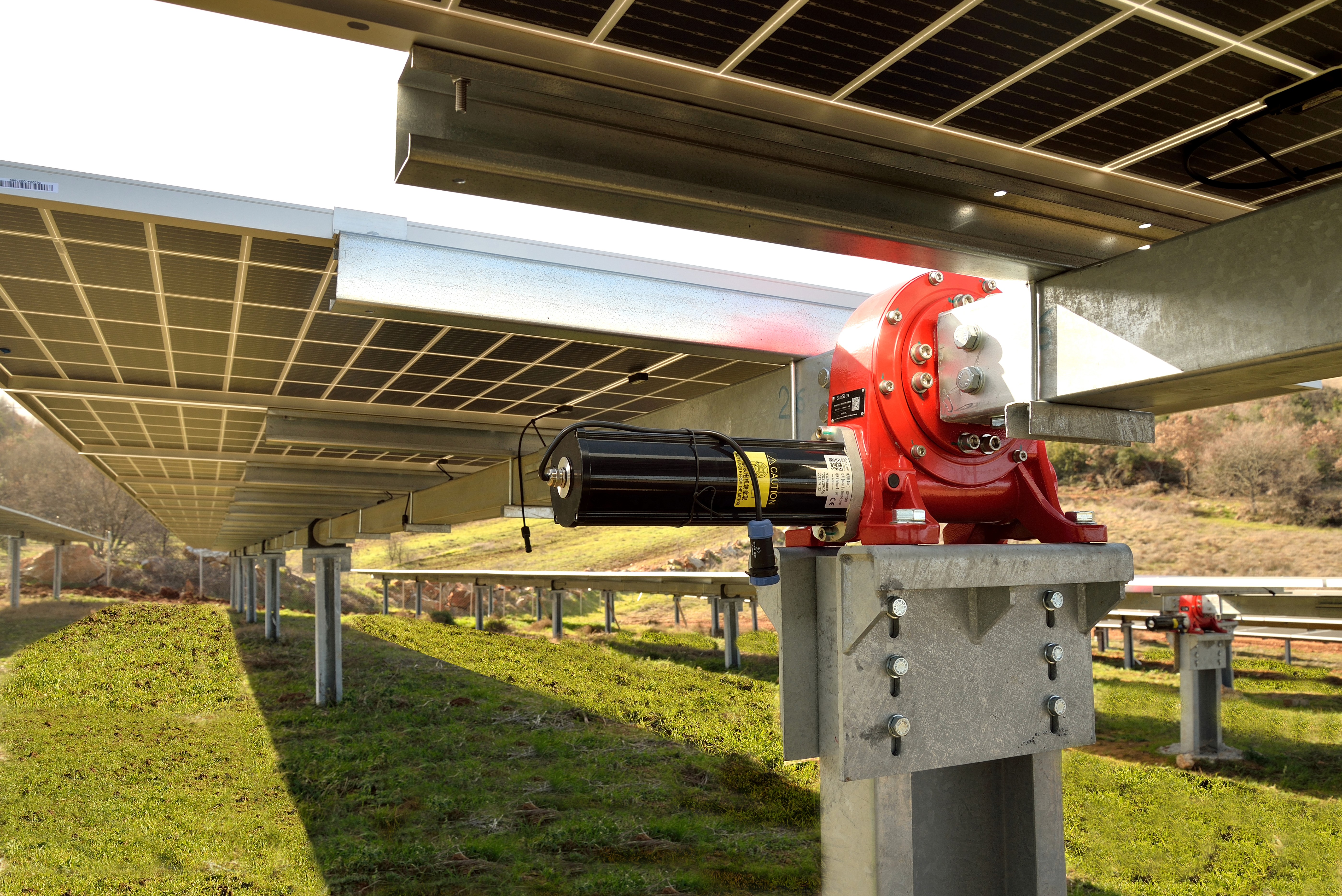 Hydraulic tracking system supporting ground-mounted photovoltaic panels in utility-scale solar installation