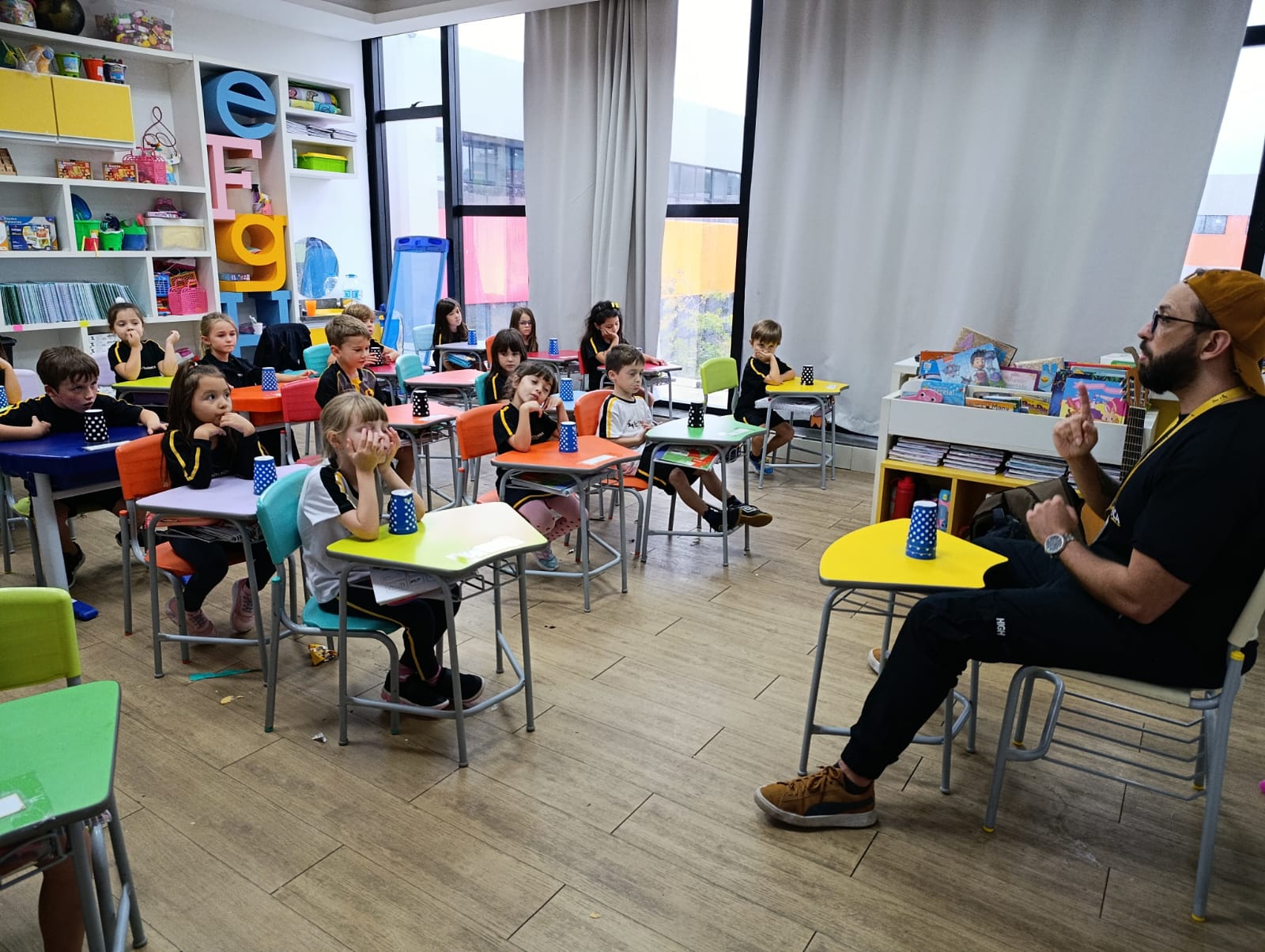 Alunos do Jardim III participam da atividade ABC dos Copos realizando sequências rítmicas com copos para desenvolver coordenação motora e percepção musical.