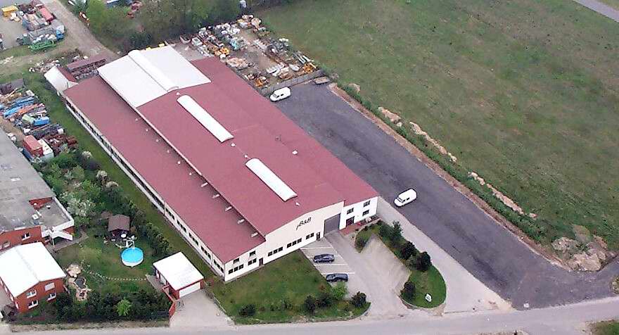 Luftaufnahme Fabrikgebäude mit rotem Dach und Bürogebäude. Industrielle Halle.